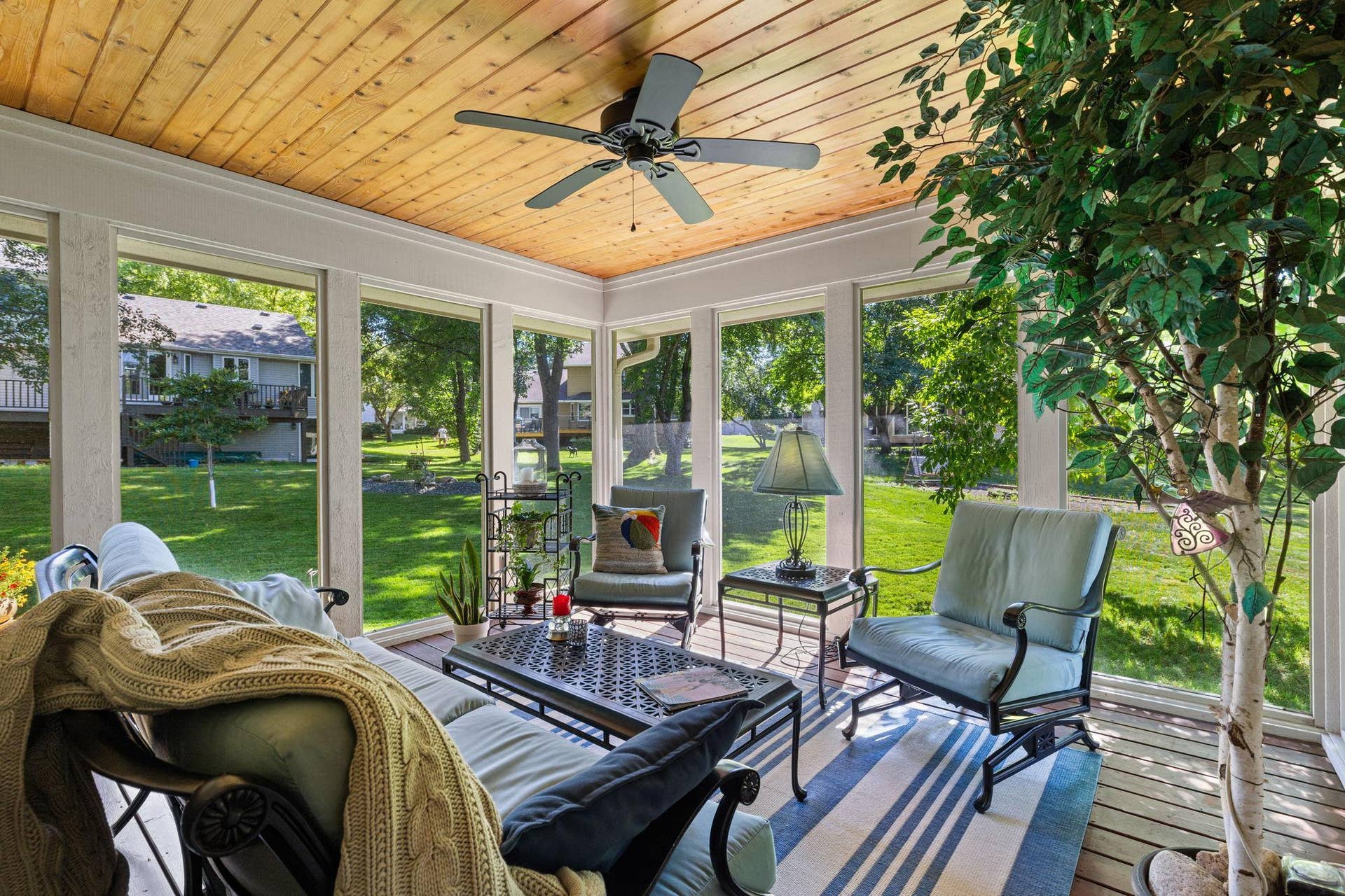 15393 Shadow Creek Road, Maple Grove, MN 55311 The walkout three-season sunroom extends the living space outdoors with a wood-paneled ceiling and ceiling fan.