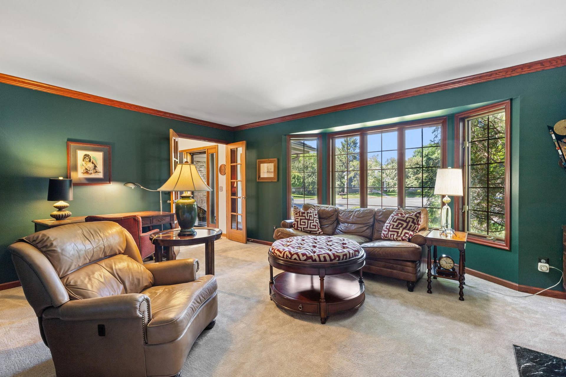 15393 Shadow Creek Road, Maple Grove, MN 55311 The main level immediately stands out with its unique details and inviting spaces. The living room feels warm and timeless with a full wall of custom built-ins, classic crown molding, and French doors that bring an added sense of charm and elegance.