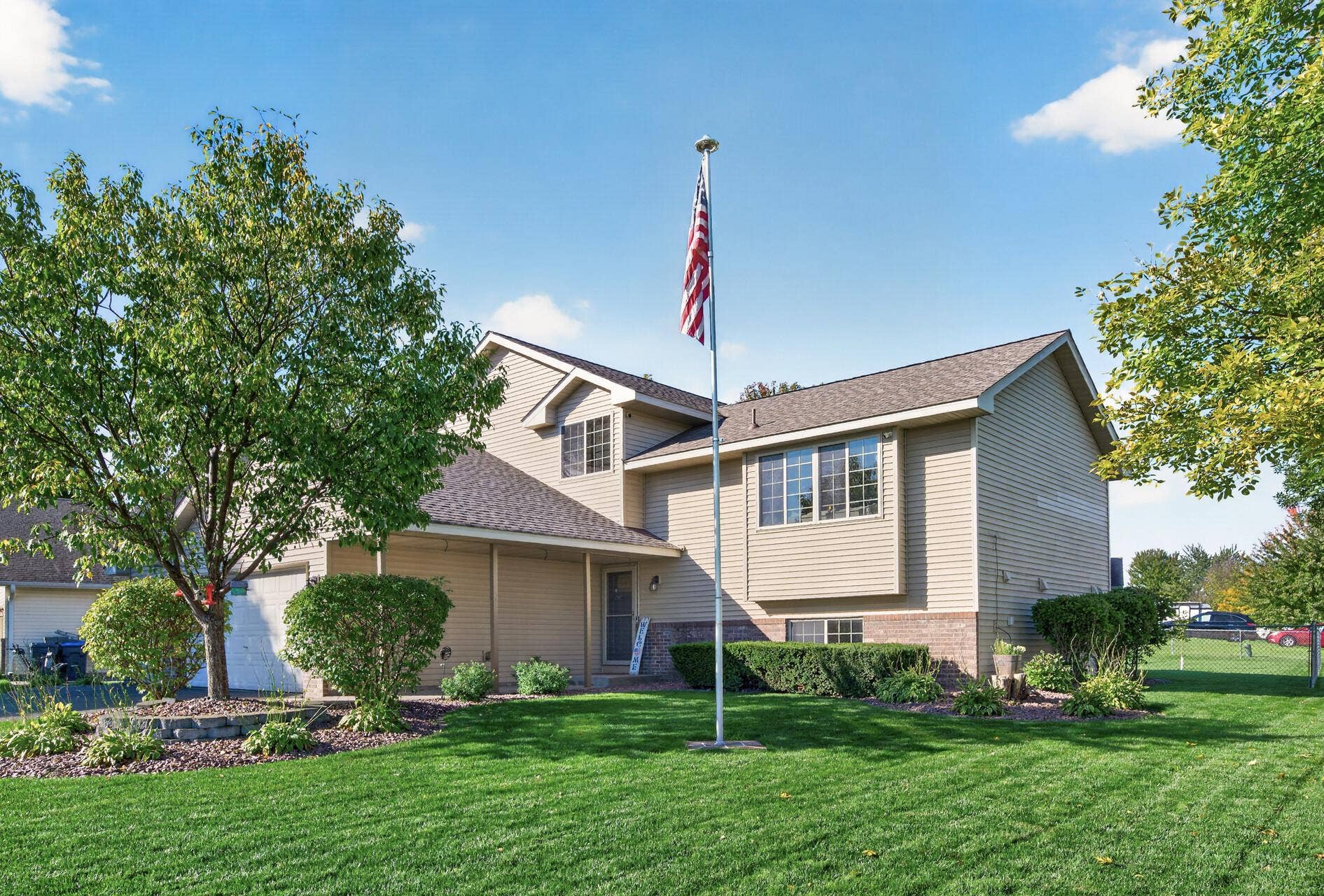 3765 Woodside Drive, Monticello, MN 55362 Beautifully maintained exterior with mature trees, lush landscaping, and a welcoming front entrance.