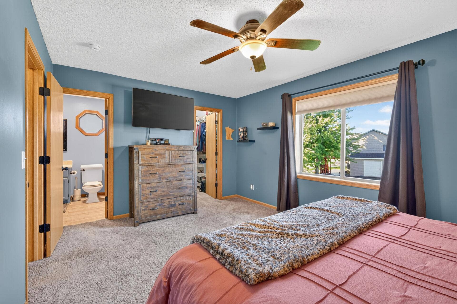 3765 Woodside Drive, Monticello, MN 55362 Spacious upper-level primary suite featuring a private bath, walk-in closet, ceiling fan, and abundant natural light.