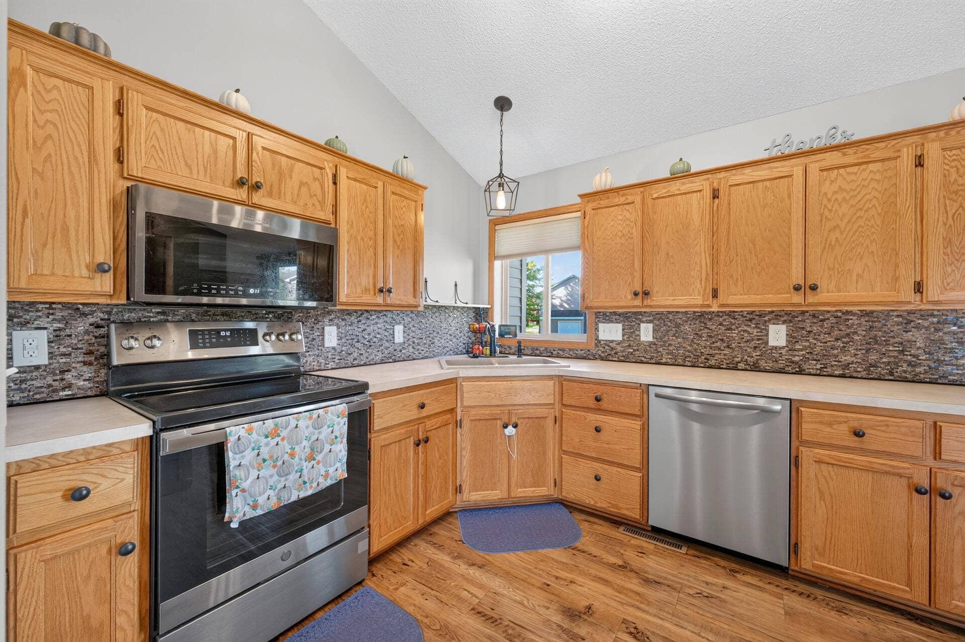 3765 Woodside Drive, Monticello, MN 55362 Bright, open kitchen featuring vaulted ceilings, abundant cabinetry, stainless-steel appliances, and plenty of counter space.