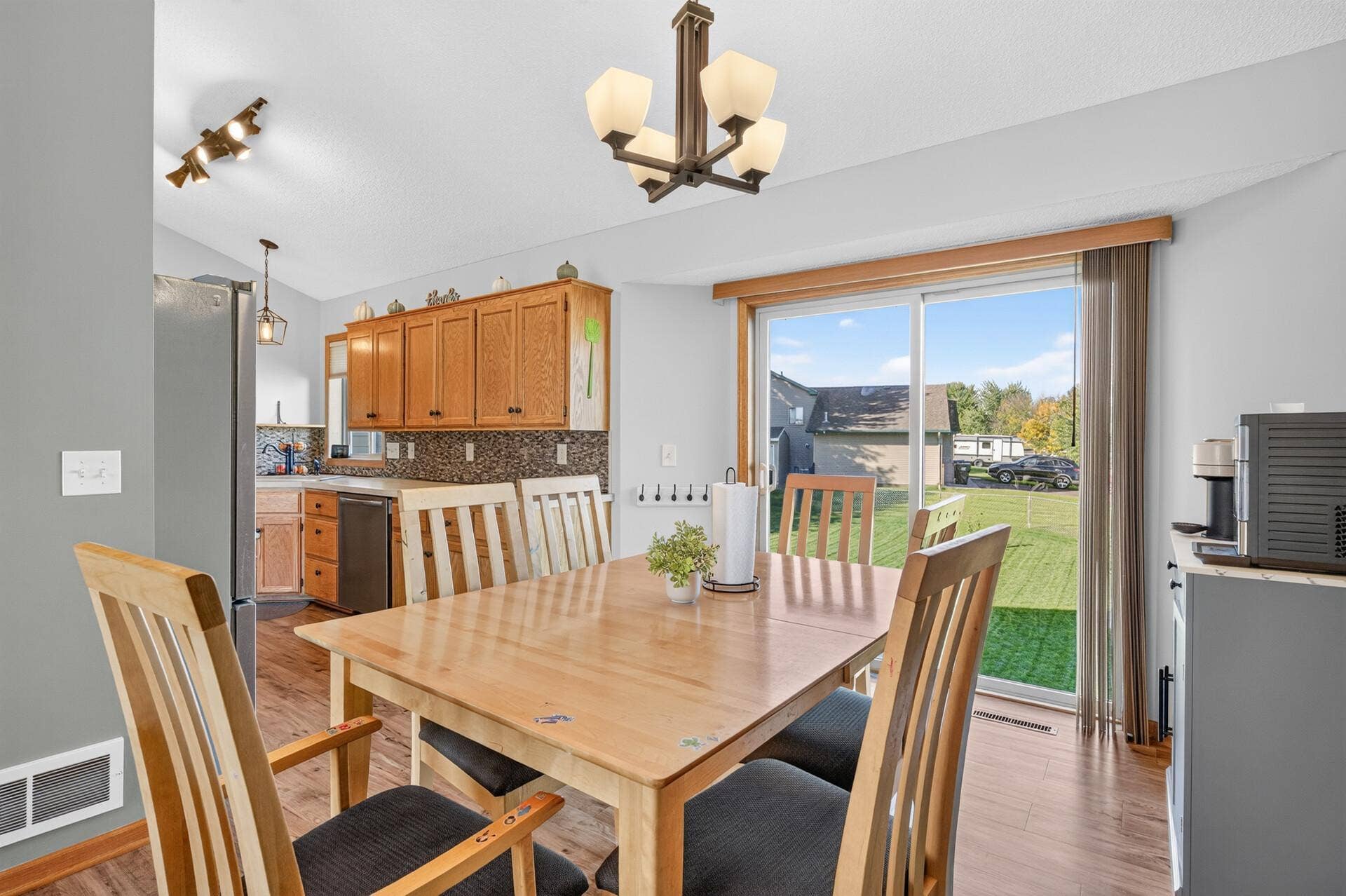 3765 Woodside Drive, Monticello, MN 55362 Spacious dining area with vaulted ceiling, abundant natural light, and sliding glass door leading to the backyard.