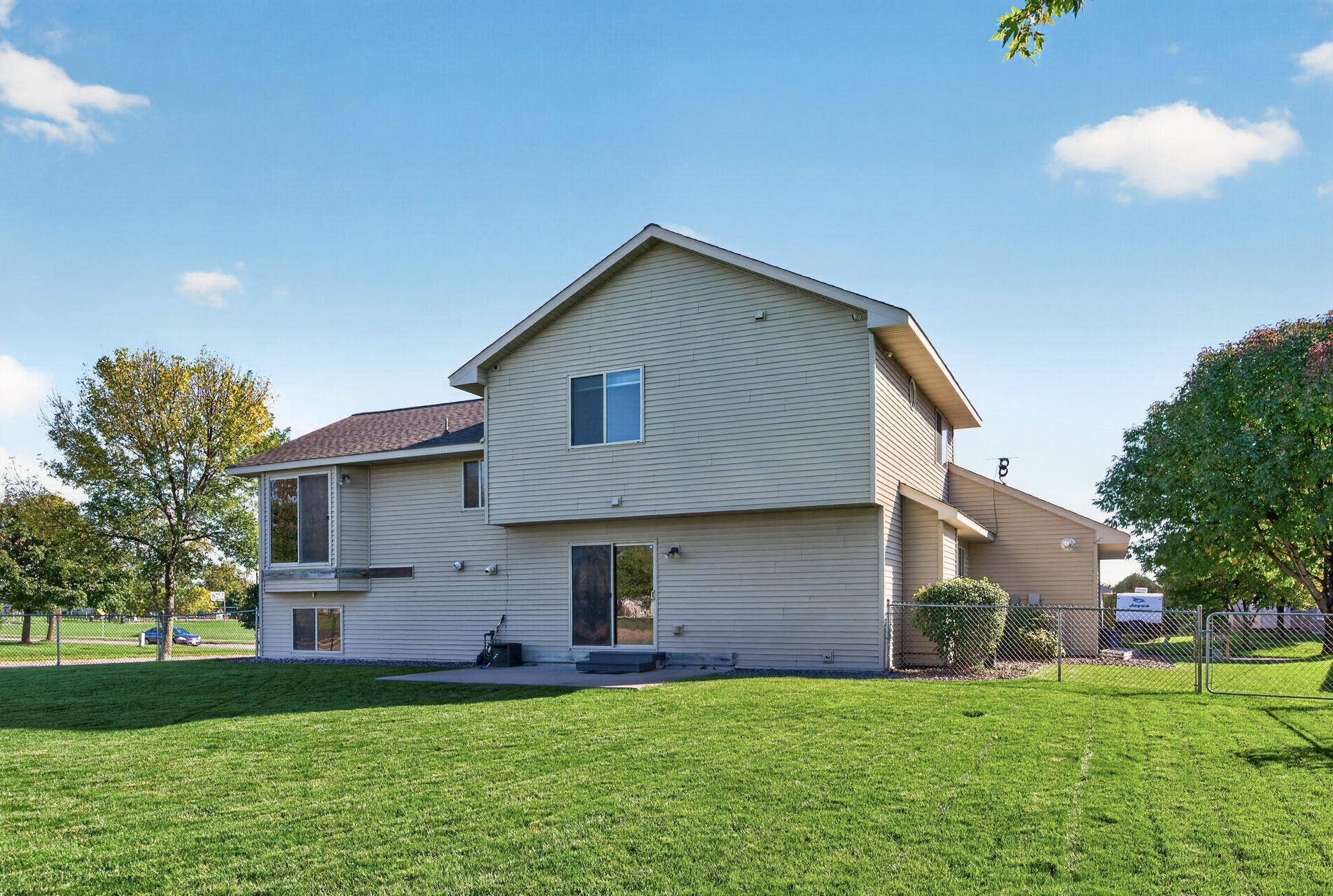 3765 Woodside Drive, Monticello, MN 55362 Rear exterior view showcases the spacious fenced backyard, concrete patio and plenty of green space for outdoor fun, pets and entertaining.