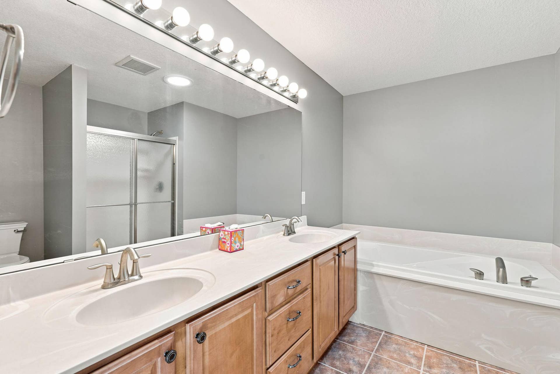 7143 Arthur Drive, Woodbury, MN 55125 Primary ensuite three-quarter bathroom includes heated flooring, soaking tub, and solar tube for added natural light.