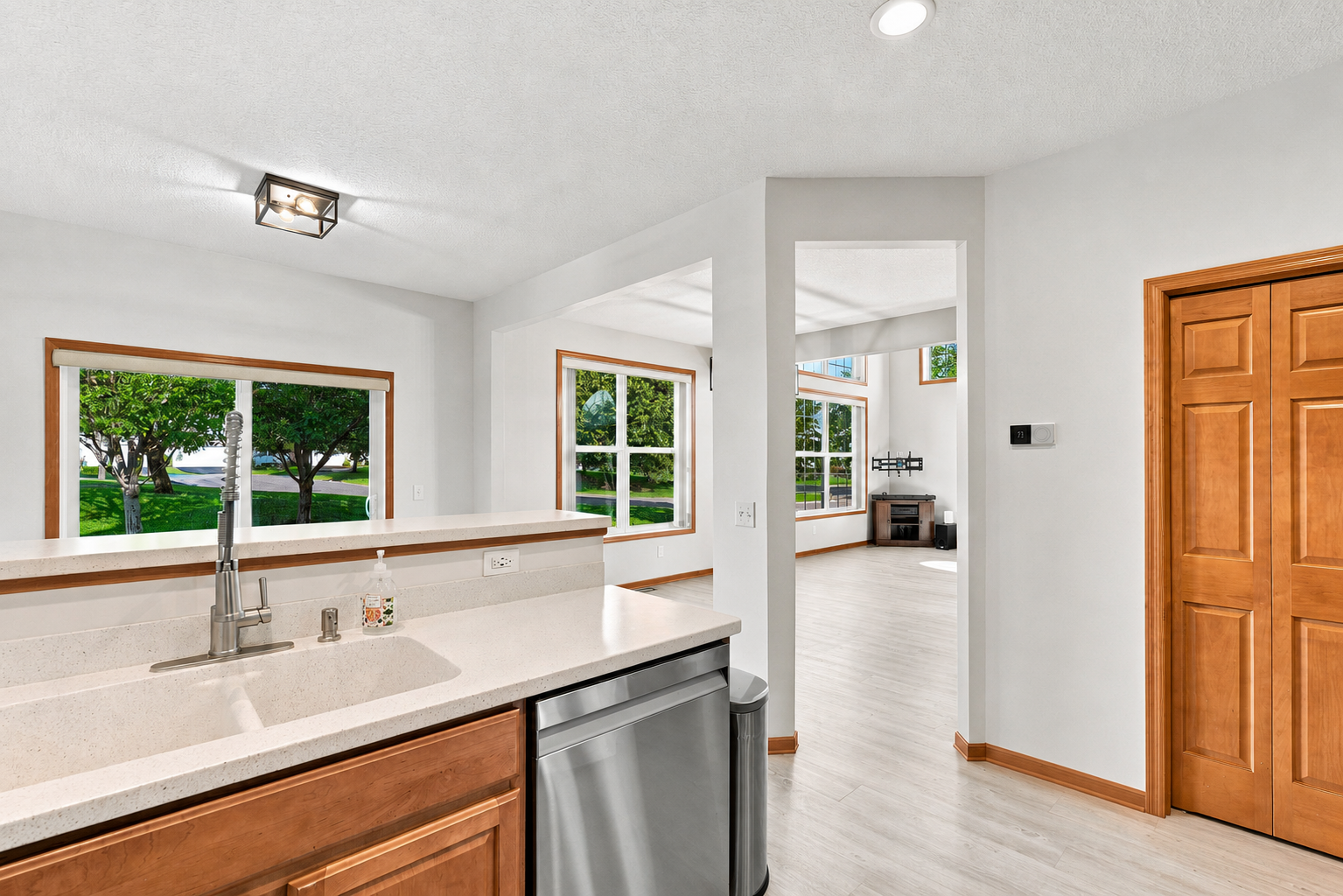 7143 Arthur Drive, Woodbury, MN 55125 Kitchen with raised breakfast bar flows to dining spaces and outdoor patio.