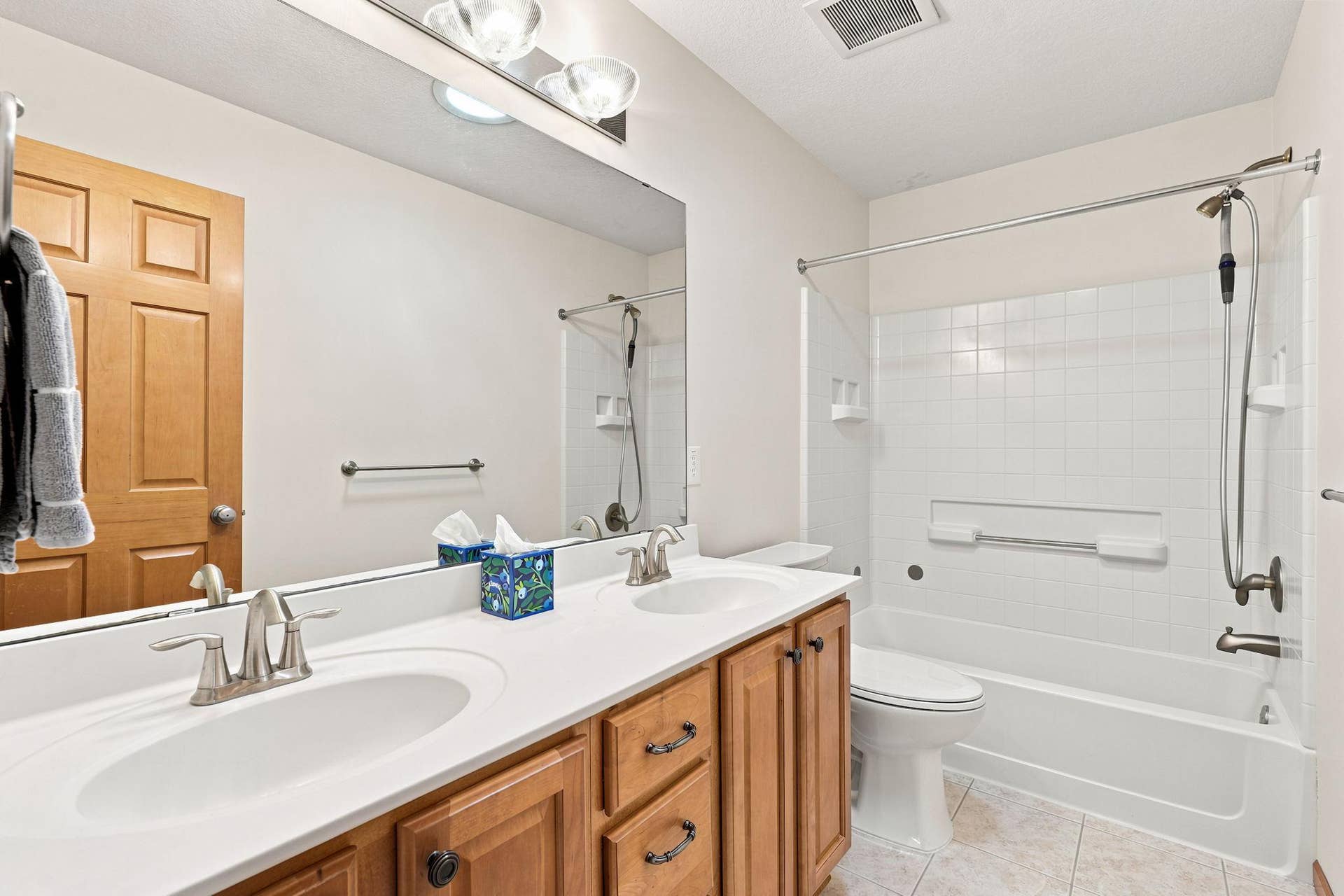 7143 Arthur Drive, Woodbury, MN 55125 Tiled upper level full bathroom with double sink vanity, soaking tub, and bright solar tube.