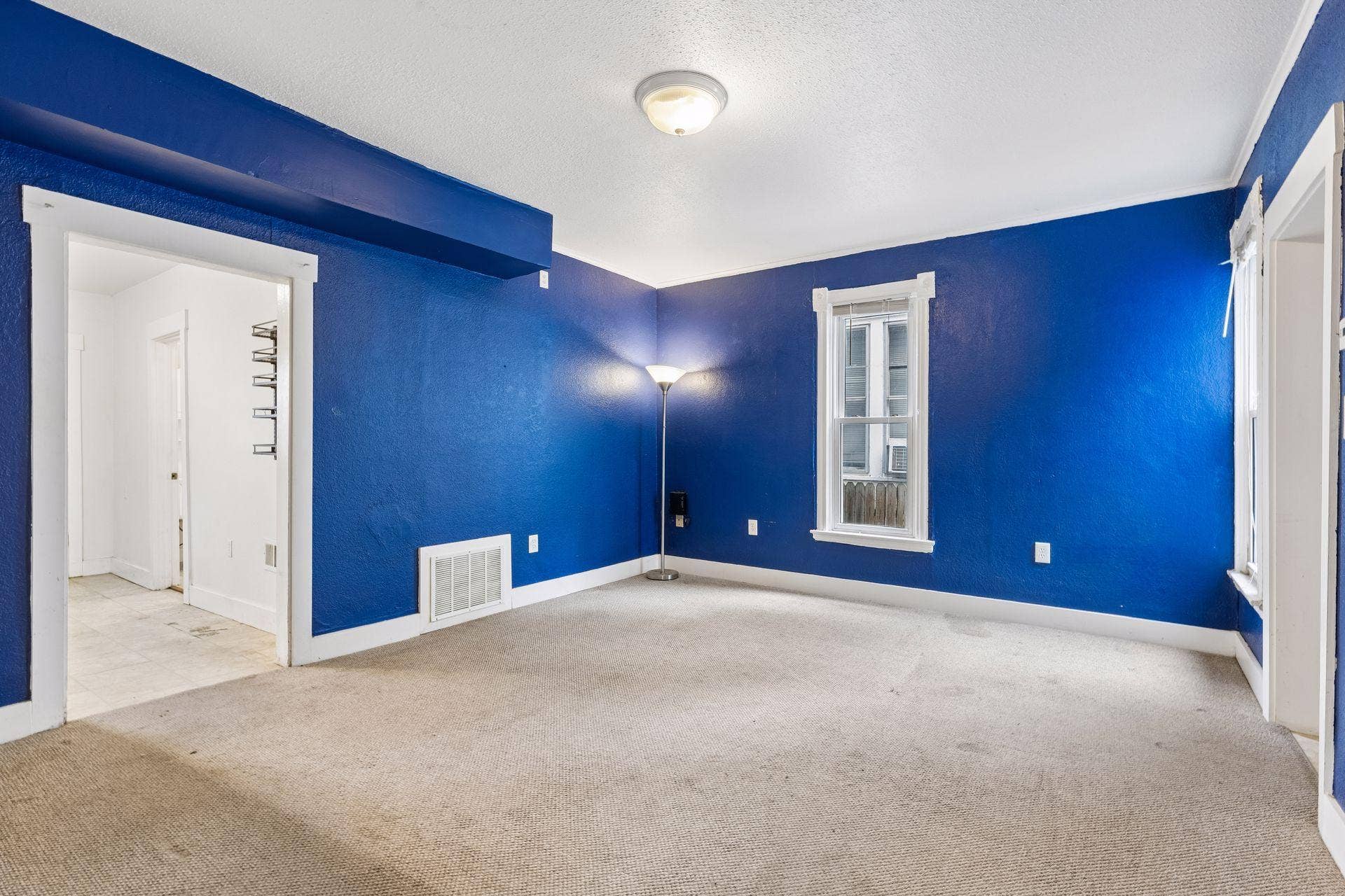 2533 Polk Street NE, 2, Minneapolis, MN 55418 Unit 2: A spacious living room with carpet flooring, overhead lighting, and windows providing plenty of natural light.