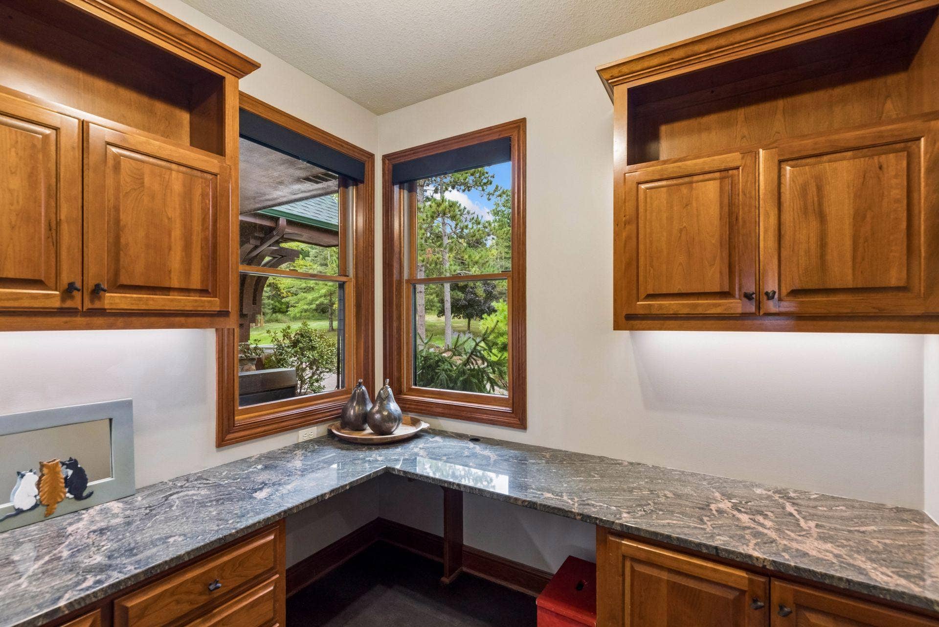 Command center with custom cherry built-ins, granite work surfaces, and under-cabinet lighting, tucked just off the kitchen
