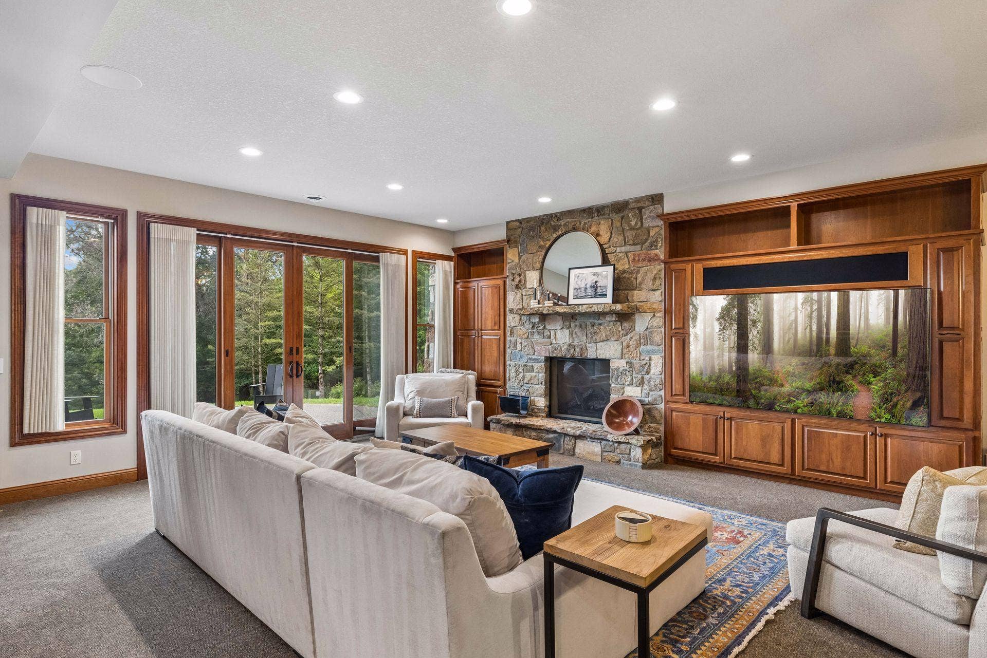 Cozy lower level family room with stone fireplace and French doors opening to St. Croix Valley views