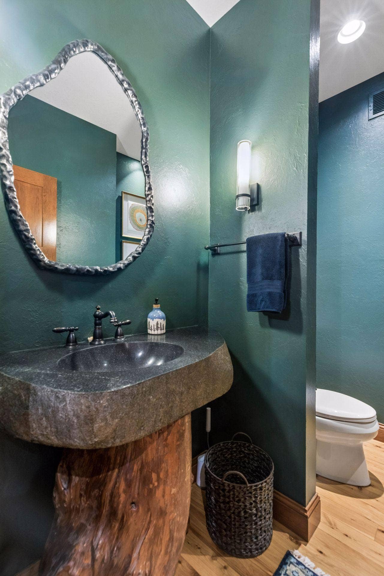 Main floor powder room embodies the natural surroundings of this property
