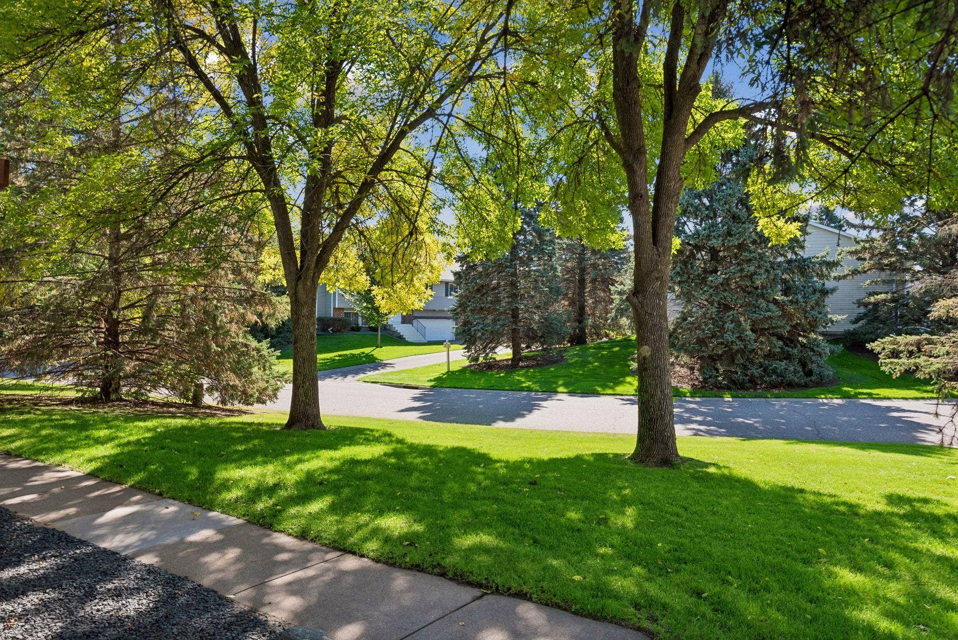 7638 13th Street N, Oakdale, MN 55128 Sunlight filters through mature trees, bringing shade, greenery and a beautiful outlook to the shared outdoor space.