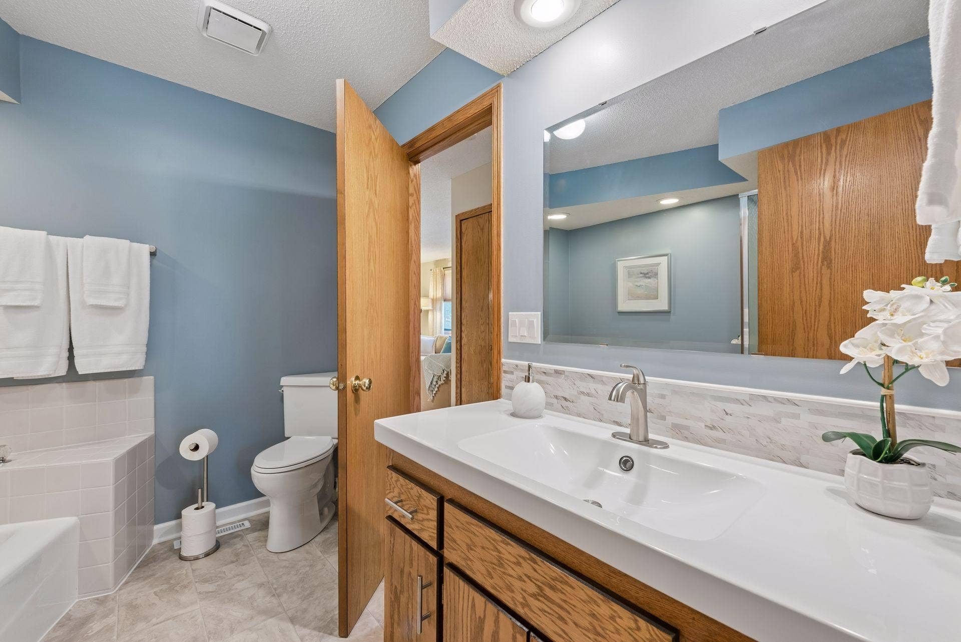 7638 13th Street N, Oakdale, MN 55128 Comfort and convenience in the primary bedroom: direct bathroom access on the left, the hallway ahead, and an exceptionally spacious walk-in closet with new shelving behind the door on the right.