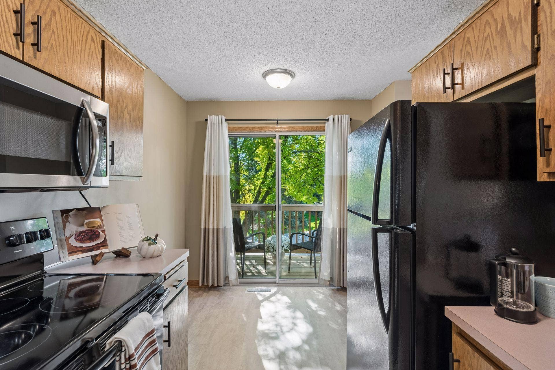 7638 13th Street N, Oakdale, MN 55128 Morning coffee is just steps awaysliding doors lead from the kitchen to the brand-new deck, where mature trees create a cozy setting with welcome privacy.