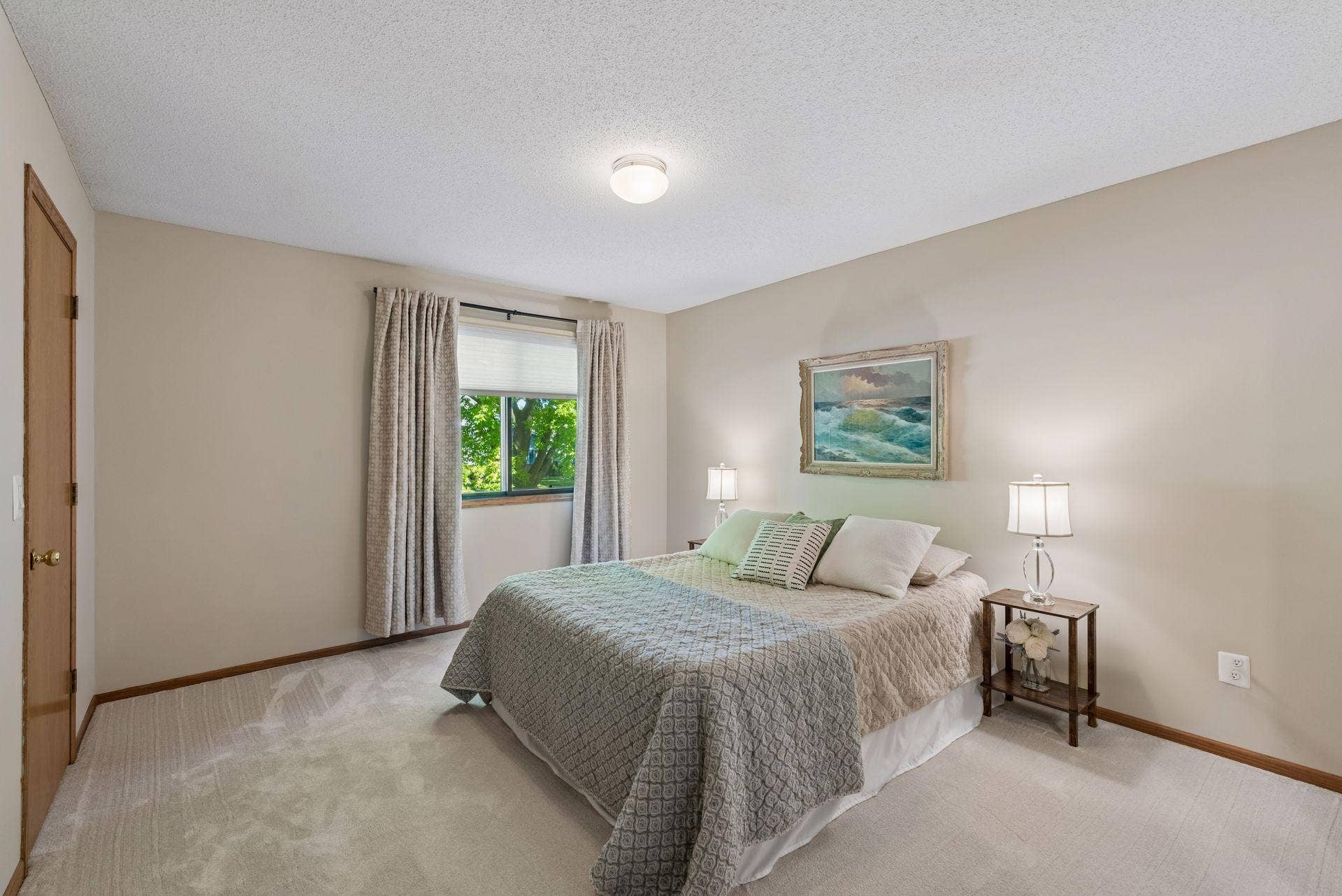 7638 13th Street N, Oakdale, MN 55128 A restful primary bedroom with fresh paint, new carpet and a leafy view, plus an exceptionally spacious walk-in closet with new shelving.