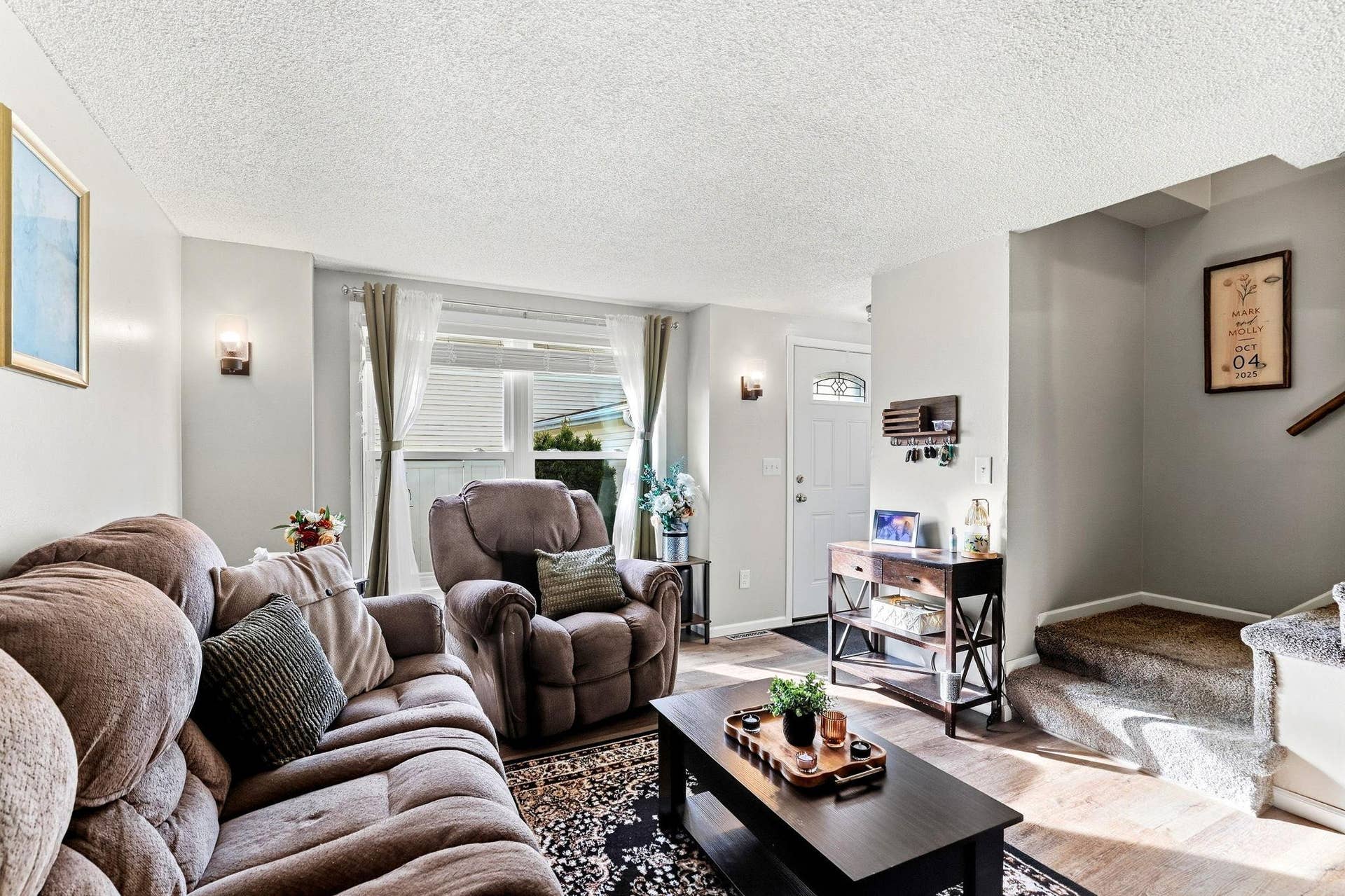 A large front window brings great natural light into the Living Room, complemented by newer LVP flooring and white trimwork.