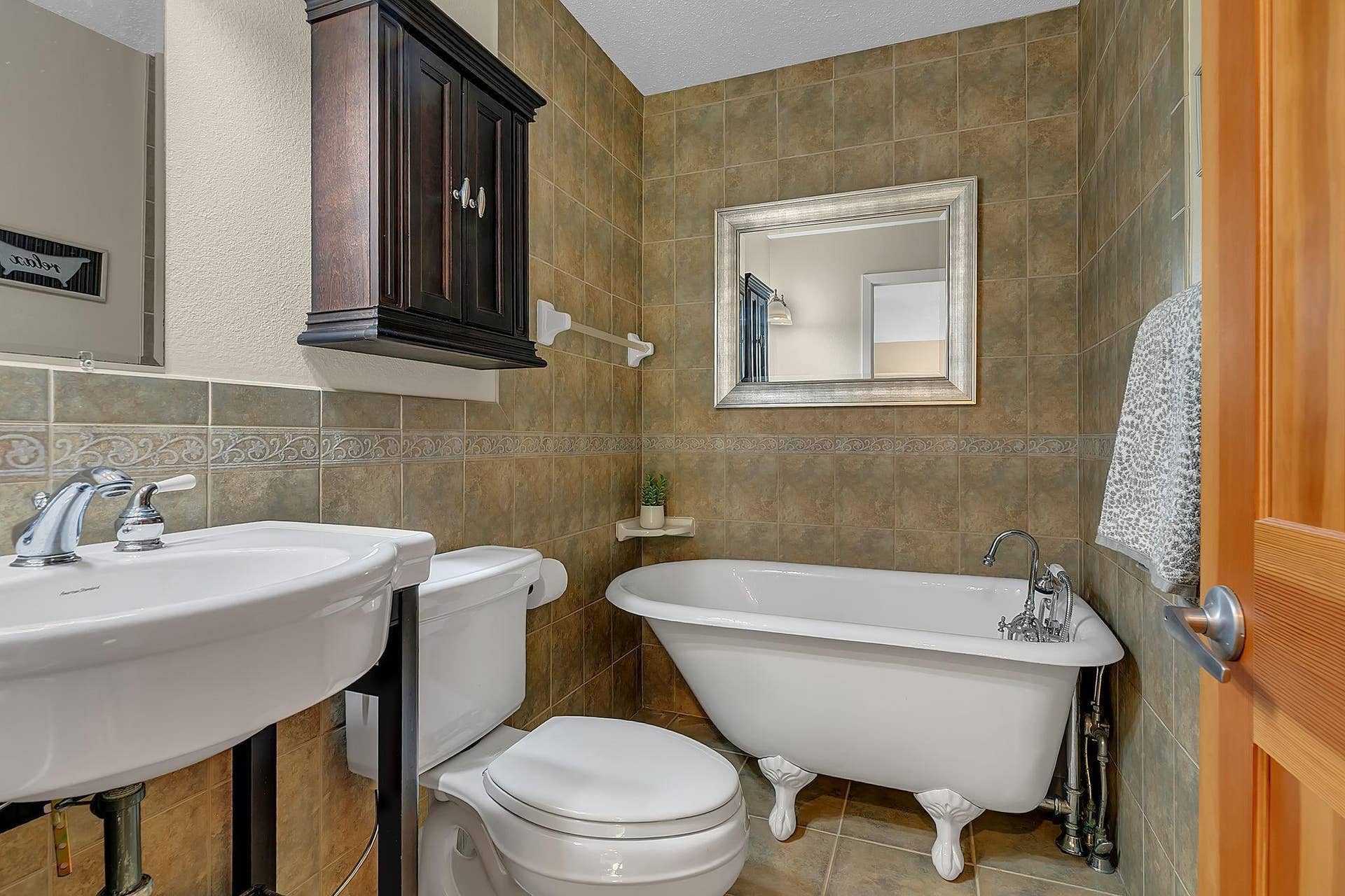 Charming main-level 3/4 bath with a classic clawfoot tubperfect for a relaxing soak after a day on the links or the lake