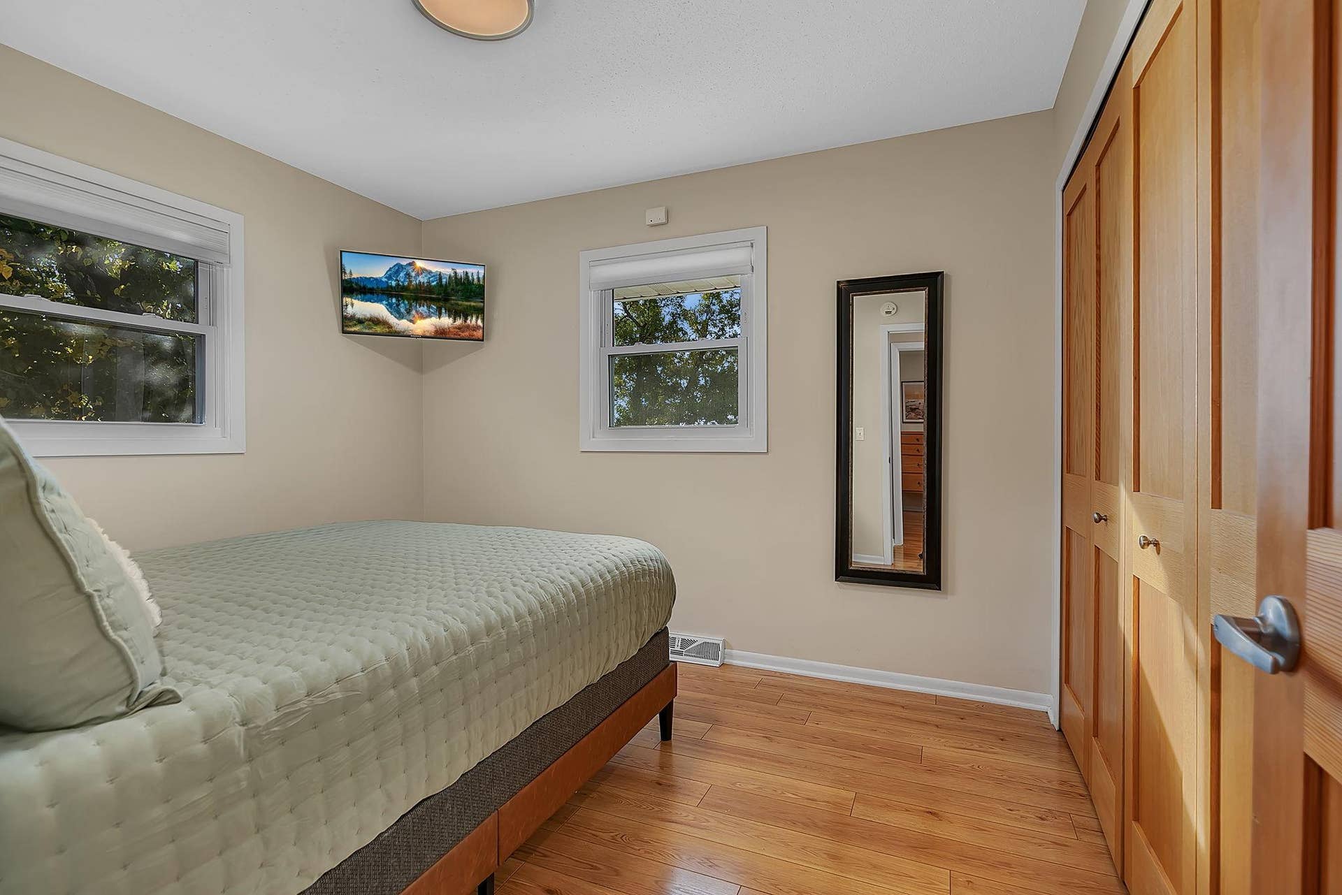 First bedroom on the main level. Solid core paneled doors, new lighting and custom closet organizers. Views of the lake!