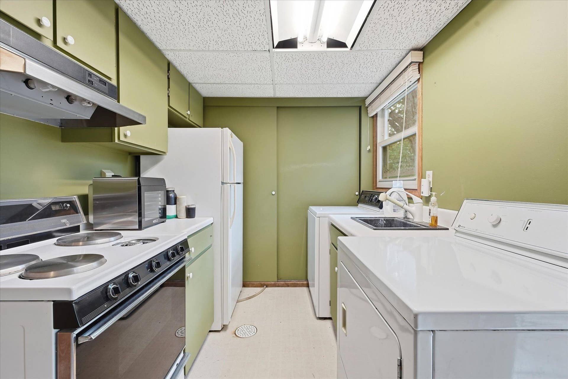 20761 187th Avenue NW, Big Lake, MN 55309 Versatile lower-level laundry room featuring a convenient second kitchen with stove, refrigerator, sink, cabinetry, and counter space.