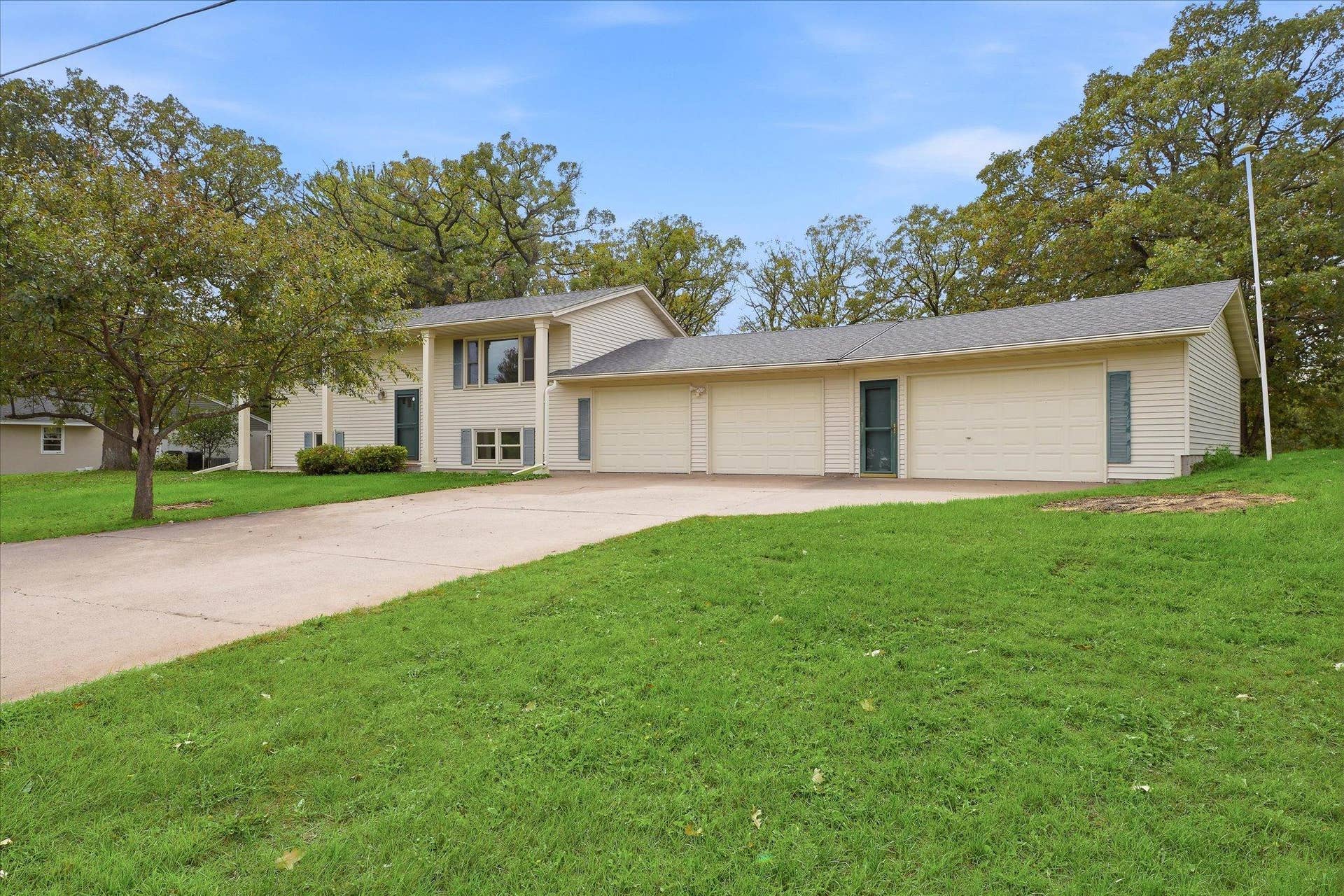 20761 187th Avenue NW, Big Lake, MN 55309 Welcoming front exterior with a large three-car garage, generous driveway, mature landscaping, and plenty of additional parking space.