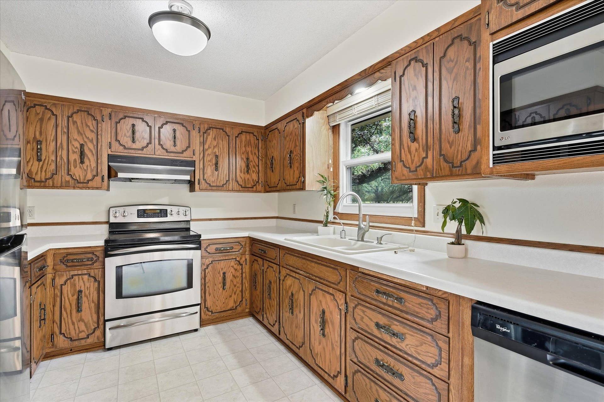 20761 187th Avenue NW, Big Lake, MN 55309 Generously sized kitchen offers an abundance of cabinetry and countertop space, stainless steel appliances, and a window above the sink overlooking the wooded backyard.