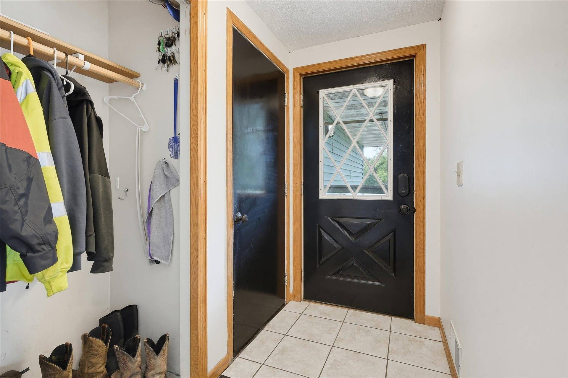 20720 187th Avenue NW, Big Lake, MN 55309 Functional front entry with tile flooring, access to the garage, convenient coat storage, and warm natural wood trim.