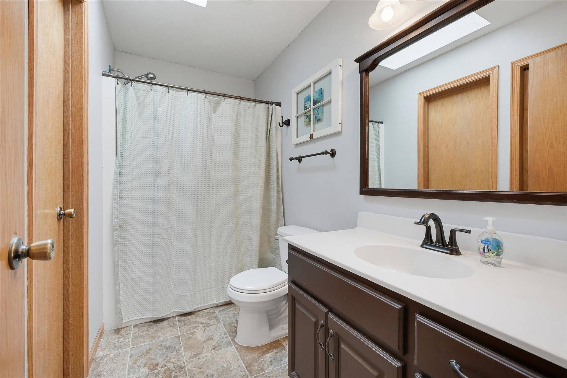 20720 187th Avenue NW, Big Lake, MN 55309 Walk-through full bathroom is accessible from both the primary bedroom and hallway and features a large vanity, tub/shower combination and skylight.