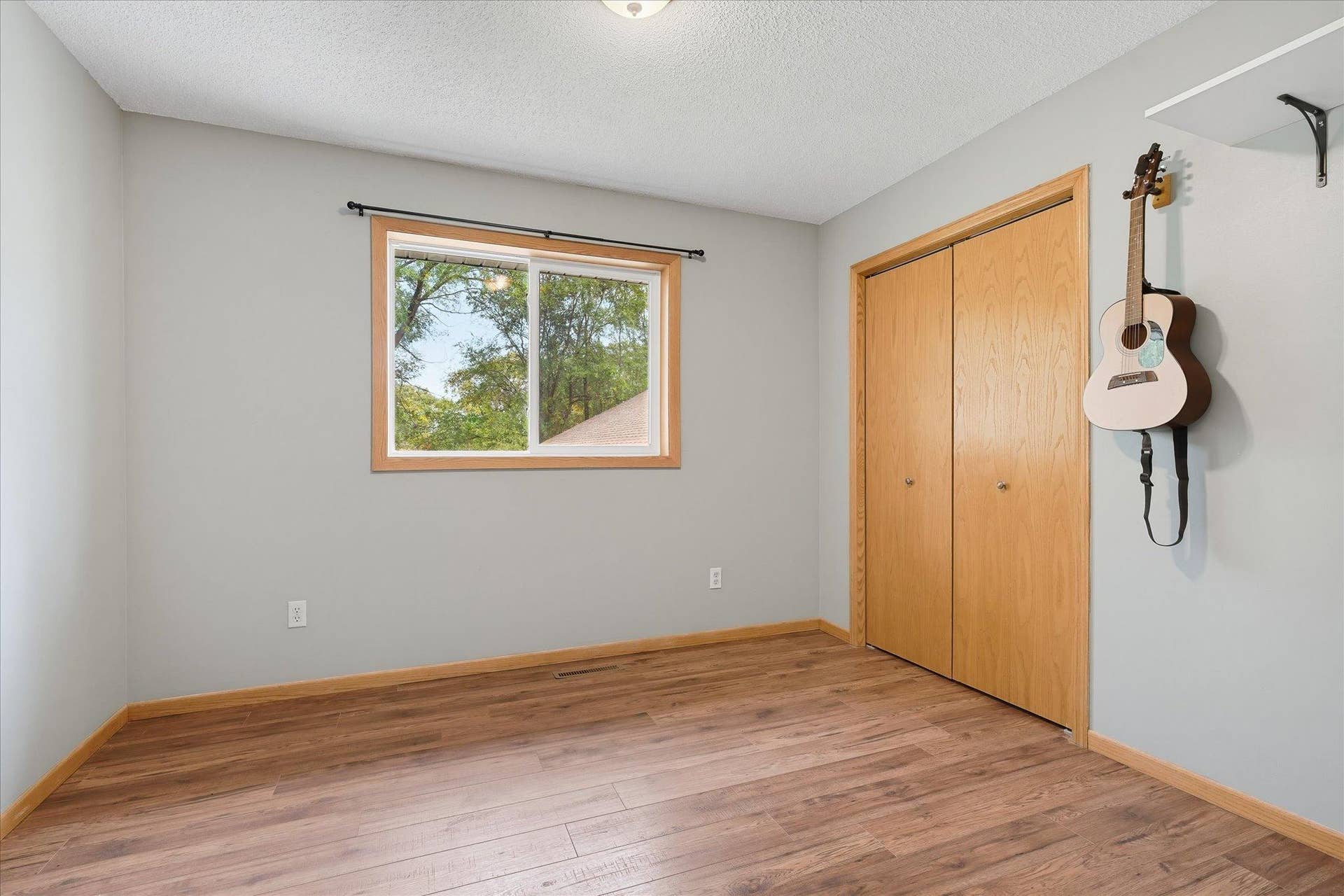 20720 187th Avenue NW, Big Lake, MN 55309 Upper-level bedroom features updated LVP flooring, neutral finishes, an updated window, and a spacious double closet.