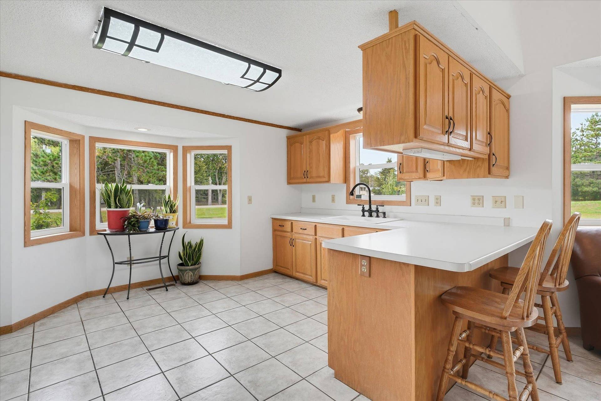 20720 187th Avenue NW, Big Lake, MN 55309 The kitchen offers abundant oak cabinetry, generous counter space, a peninsula with casual seating, tile flooring, and a charming bay-window area.