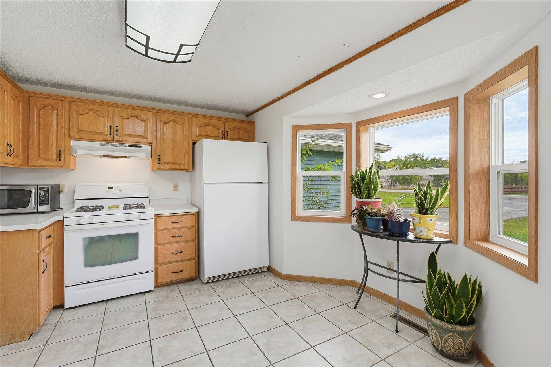 20720 187th Avenue NW, Big Lake, MN 55309 A gas range, ample cabinetry, and a charming window-lined nook overlooking the yard, perfect for a small breakfast table or additional seating area.