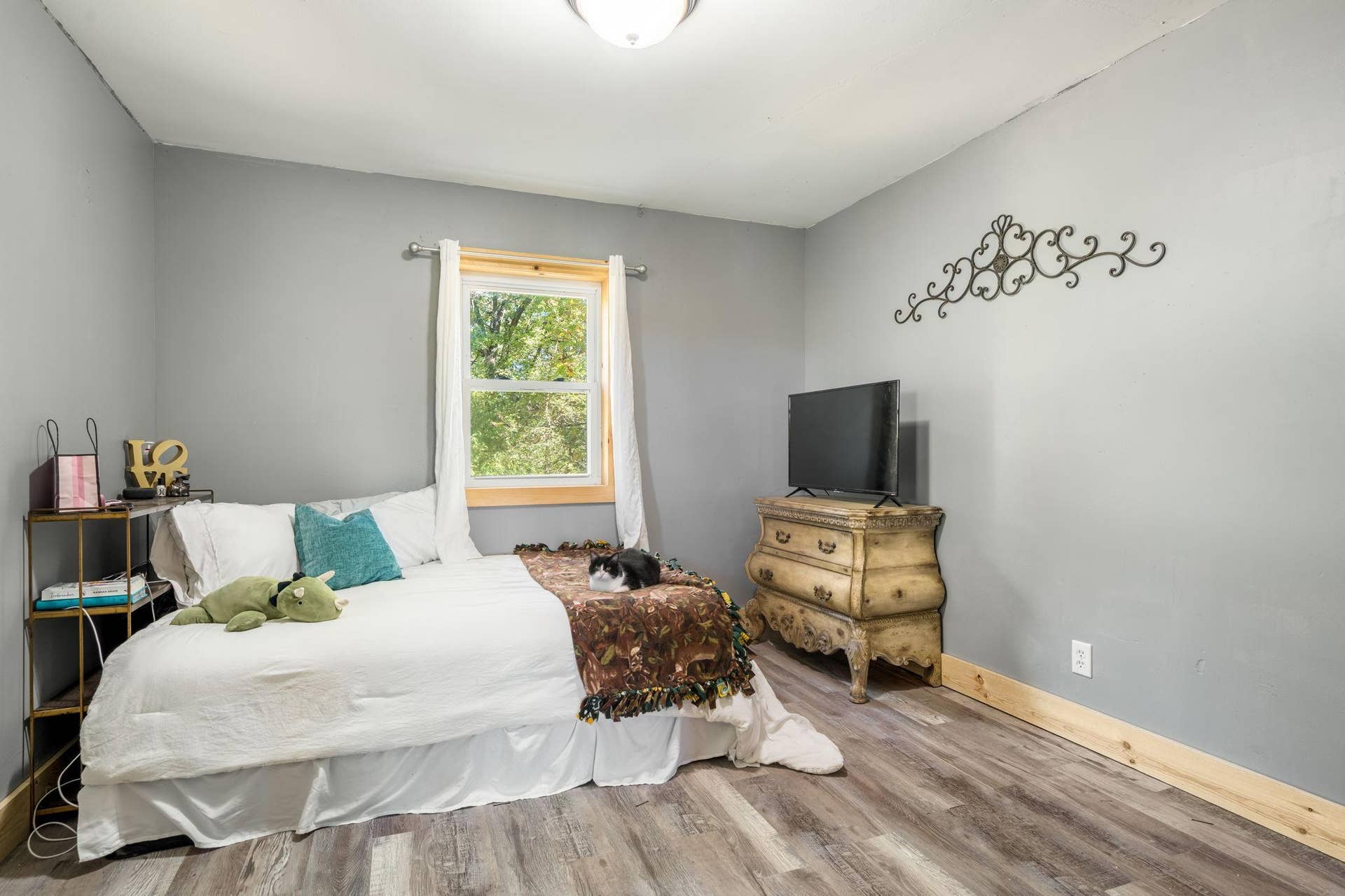 465 70th Avenue, Clayton, WI 54004 A comfortable bedroom with updated flooring, neutral finishes and a large window overlooking the wooded surroundings.