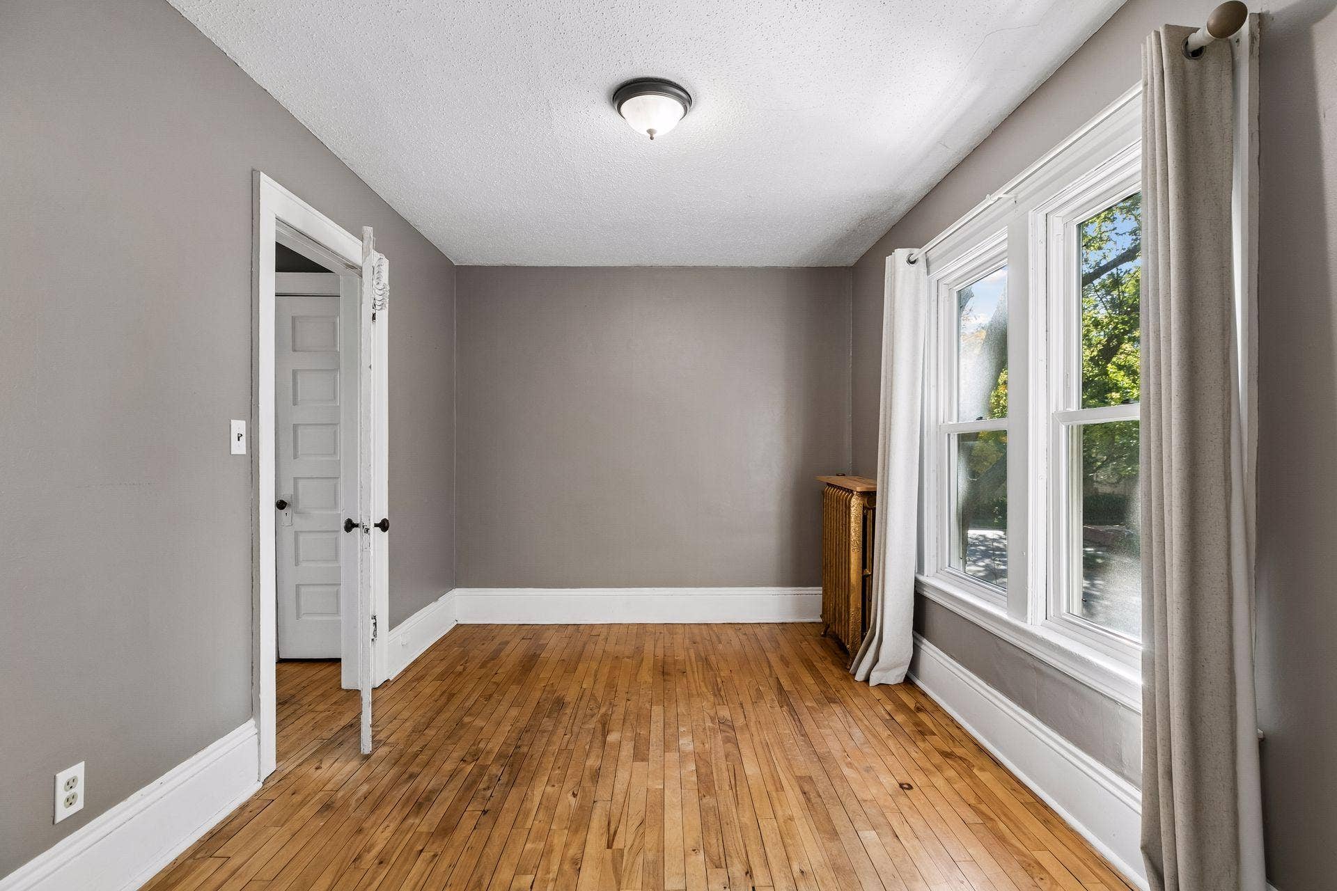 3112 E 33rd Street, 44, Minneapolis, MN 55406 The first of two upper level bedrooms provides a comfortable space with hardwood flooring, two windows, and overhead lighting.
