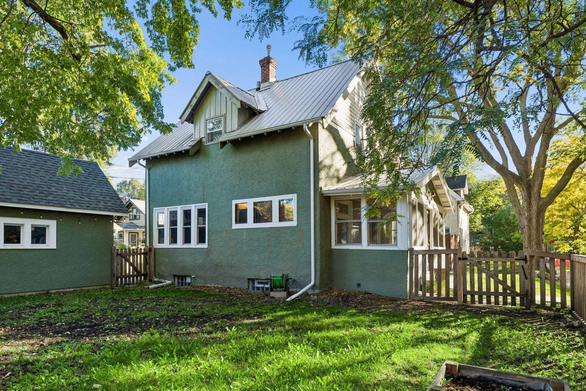 3112 E 33rd Street, 44, Minneapolis, MN 55406 Another look at the home from the fenced in yard, with durable stucco siding and a metal roof adding lasting appeal.