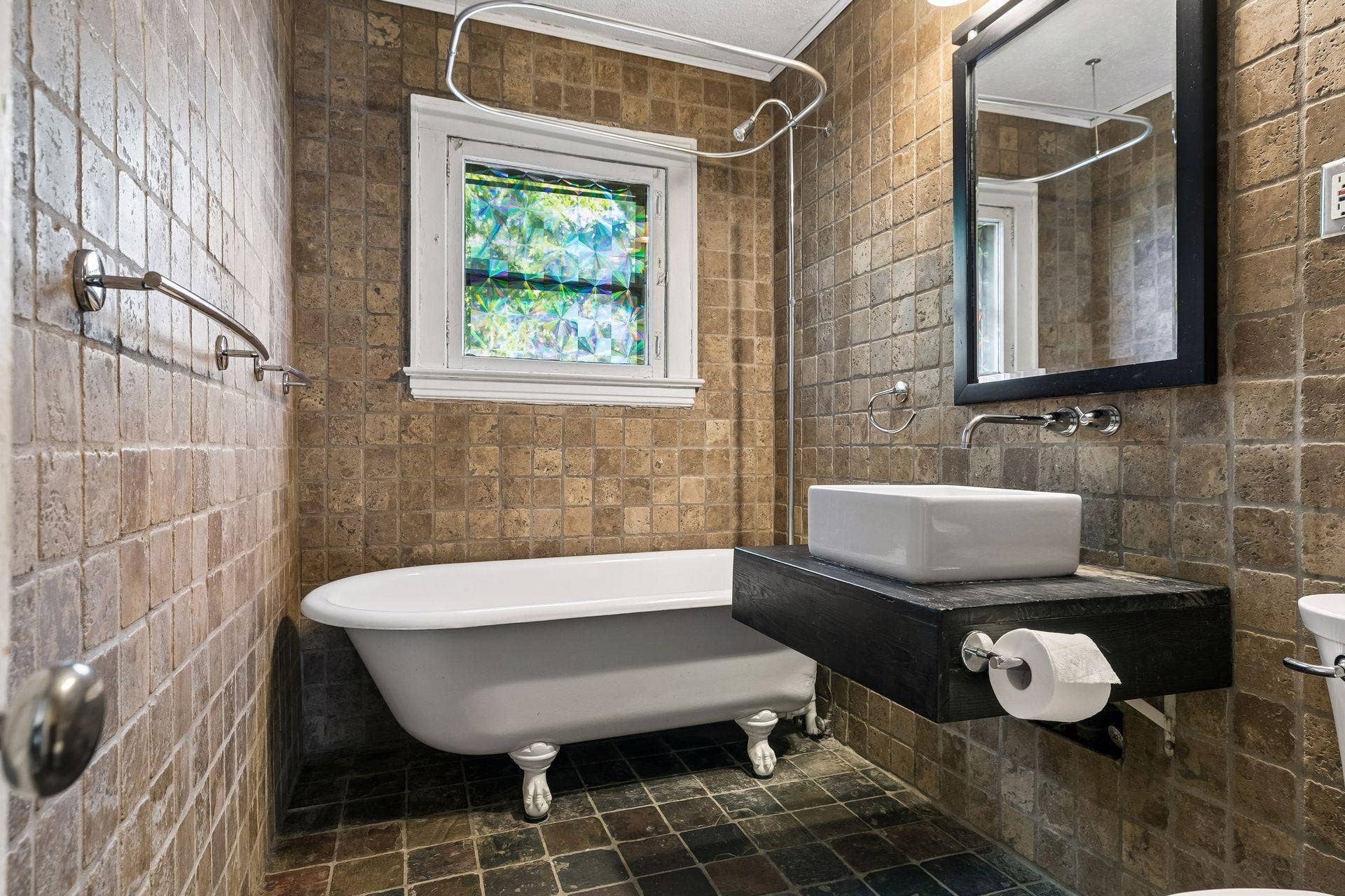 3112 E 33rd Street, 44, Minneapolis, MN 55406 Tiled floors and walls, a sleek vanity, and a classic clawfoot tub with shower head create a charming upper level full bath, complete with a bright window.