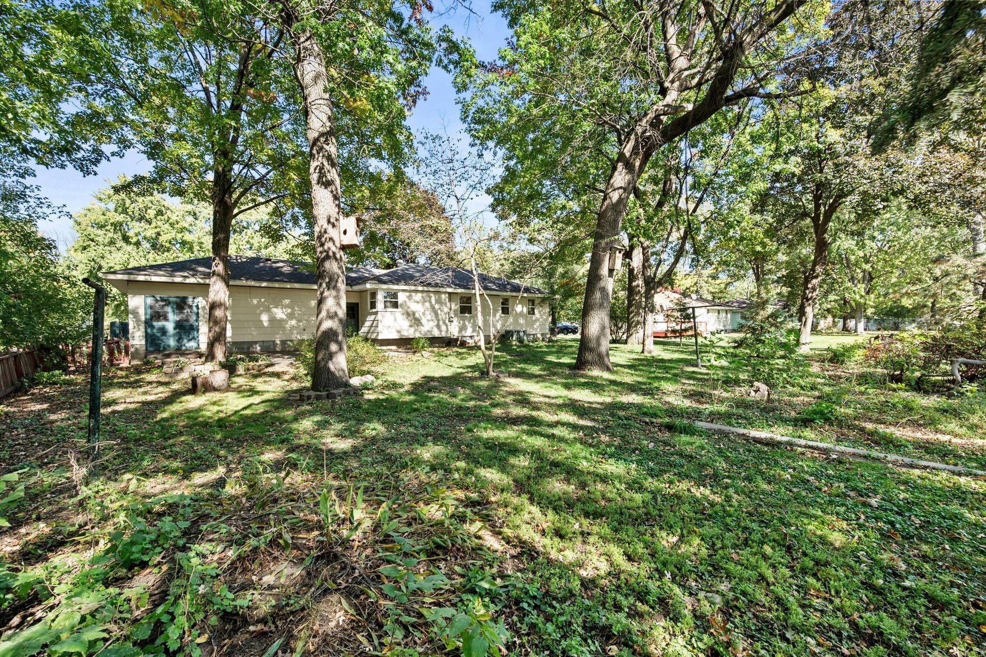 6609 74th Avenue N, Brooklyn Park, MN 55428 Out back, the yard opens to an expansive lawn dotted with mature trees, creating a peaceful, park-like backdrop with no immediate rear neighbor.