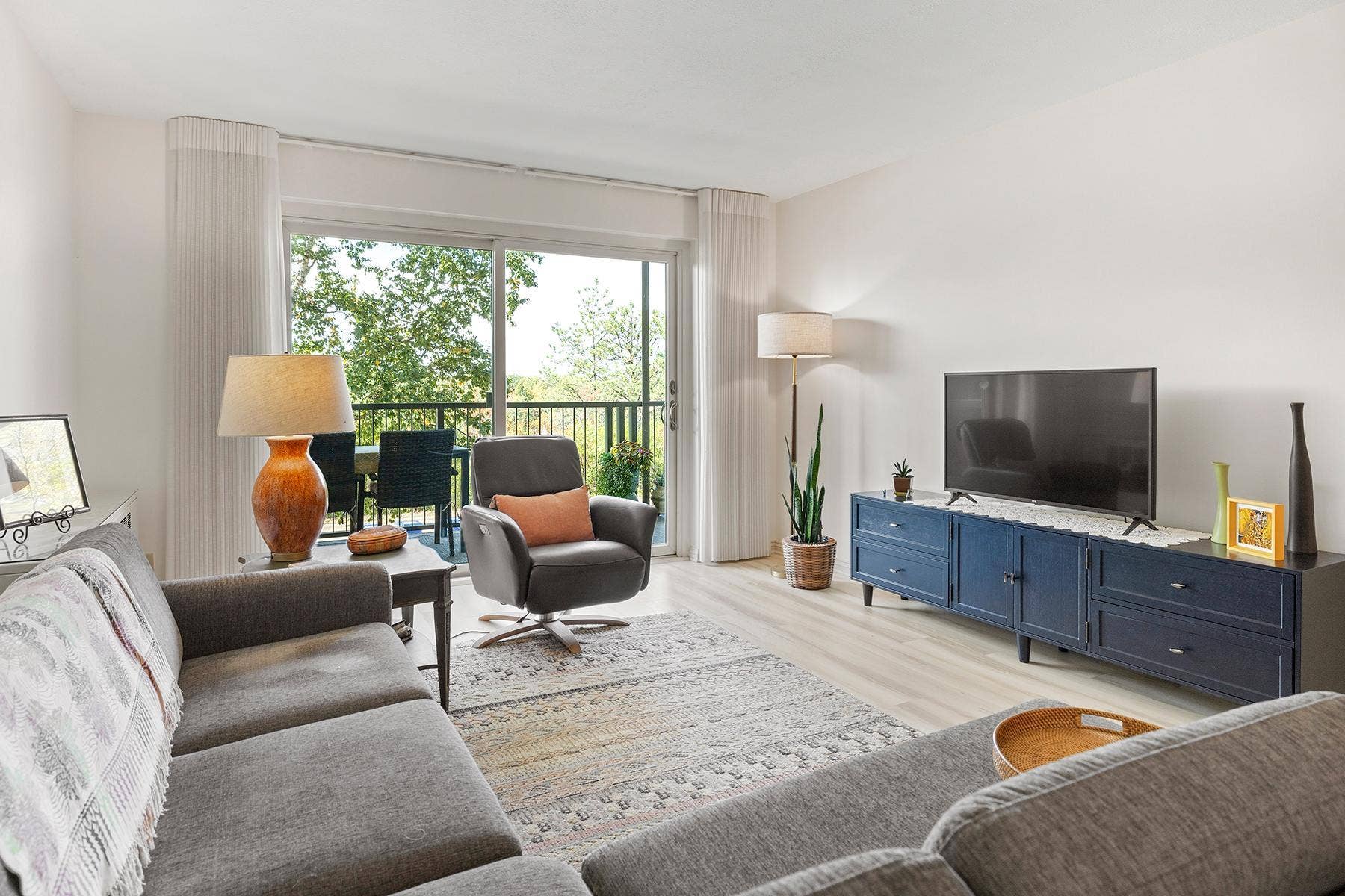 200 Mississippi River Boulevard N, #1C, 96, Saint Paul, MN 55104 Living room with sliding glass doors facing west over the Mississippi River and extending to oversized balcony (22 x 6 ft).