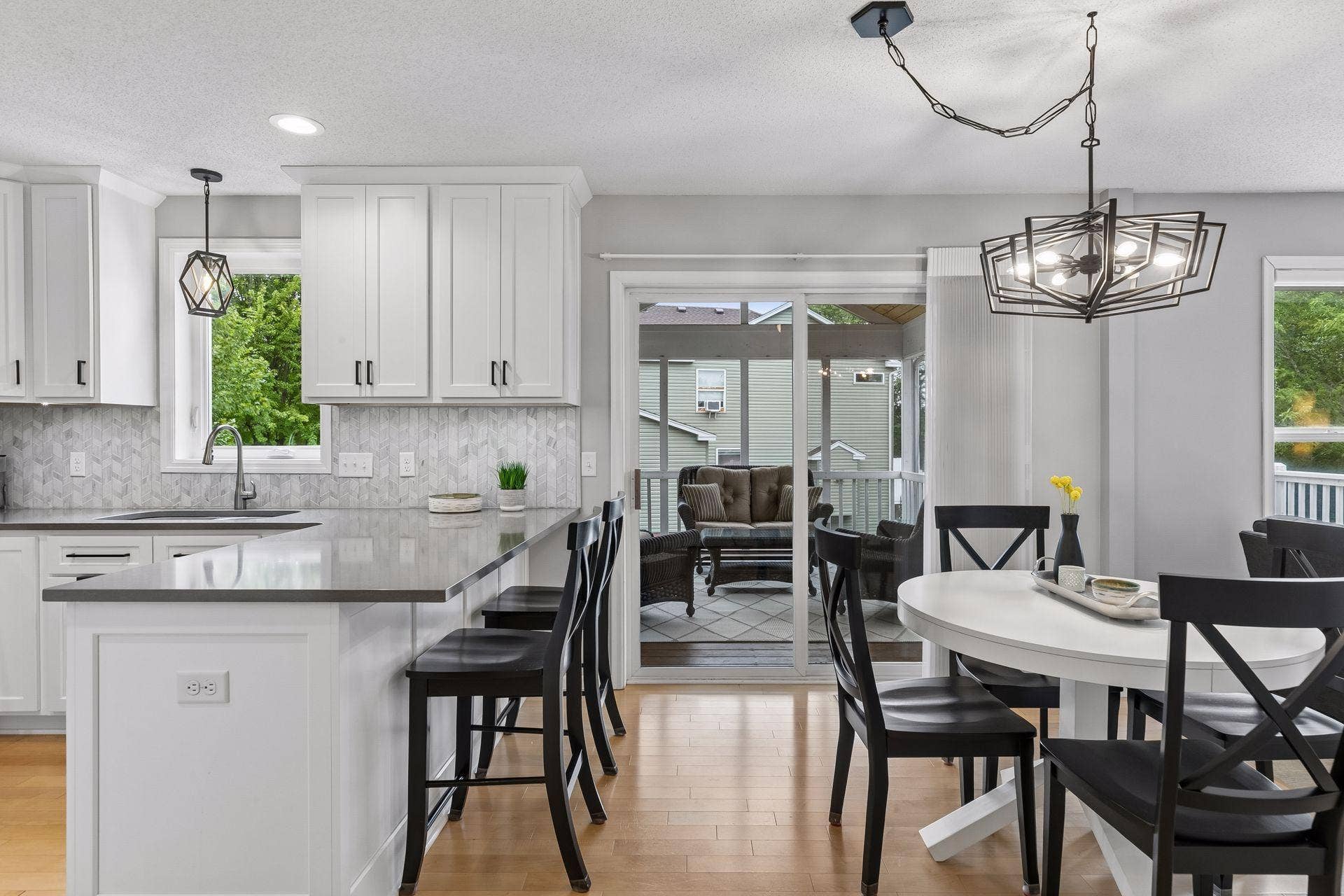 957 Lake Ridge Bay, Woodbury, MN 55129 The informal dining space connects effortlessly to the outdoors with continued hardwood flooring, stylish chandelier lighting, and sliding door access to the screened porch and deck.