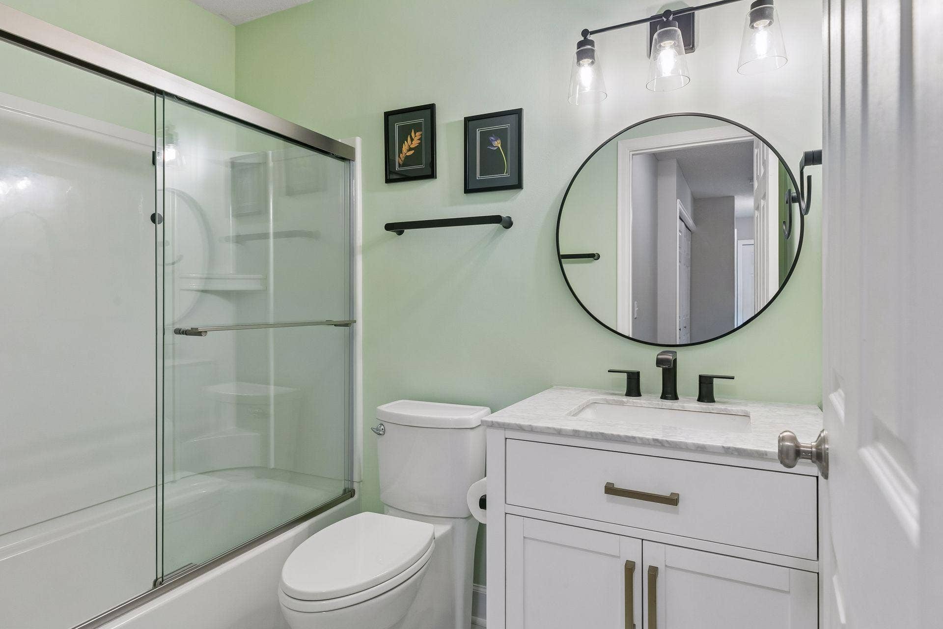 957 Lake Ridge Bay, Woodbury, MN 55129 The updated (2023) upper level bathroom combines style and function with LVP flooring, a vanity, mirror with wall lights, and tub/shower combination.
