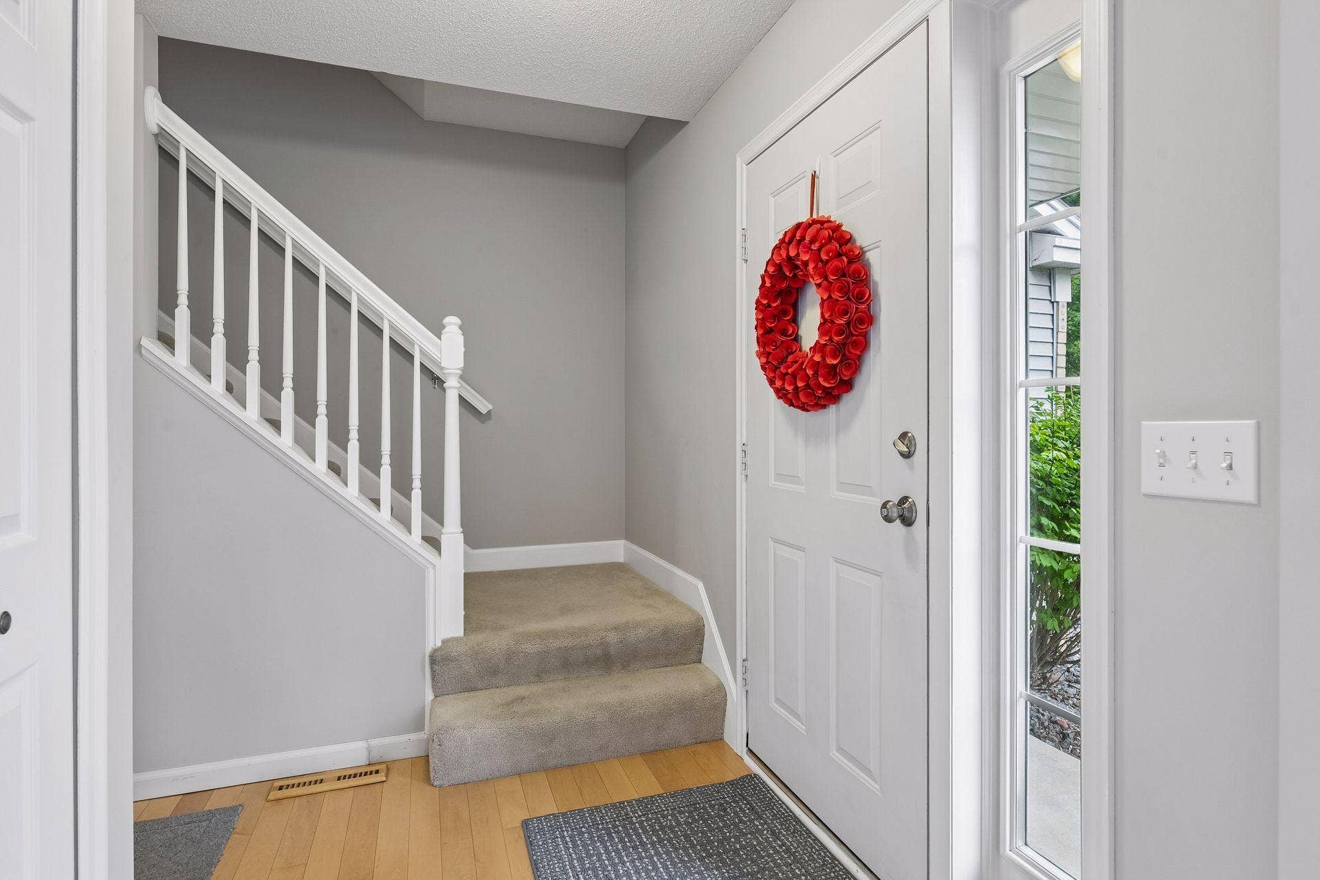 957 Lake Ridge Bay, Woodbury, MN 55129 Warm maple hardwood flooring sets the tone in the foyer, complemented by a coat closet, overhead lighting, and access to the upper level.