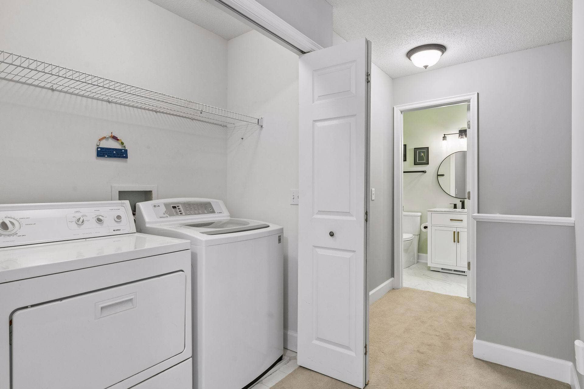 957 Lake Ridge Bay, Woodbury, MN 55129 The upper level laundry closet offers a smart use of space with a washer, dryer, and built in shelving for added storage, making laundry day a little easier!
