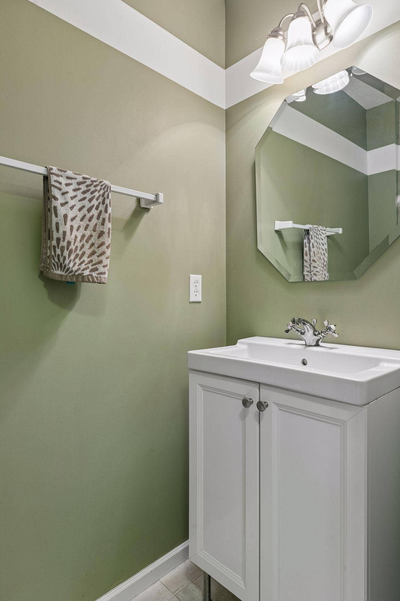 957 Lake Ridge Bay, Woodbury, MN 55129 A nicely appointed half bath on the main level offers LVT flooring, a vanity sink, mirror, and stylish wall lighting.