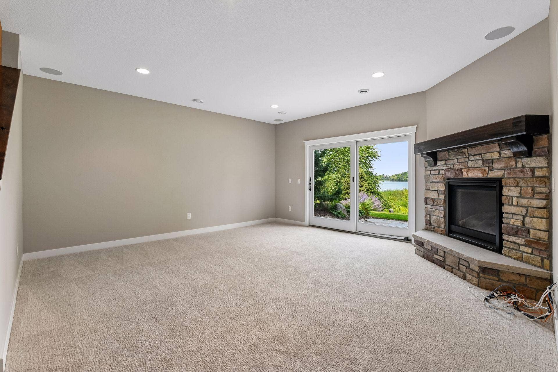 2444 Woods Drive, Victoria, MN 55386 Lower level walkout family room with a 2nd stone-surround gas fireplace and direct access to the backyard patio.