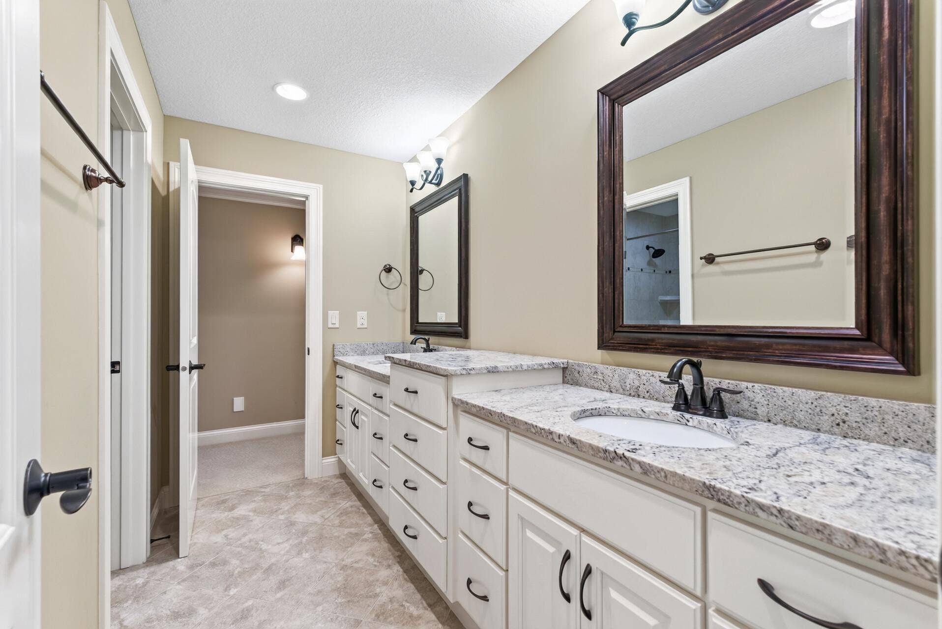 A beautifully appointed full bathroom features dual sinks and high-quality cabinetry, combining elevated finishes with plenty of space and everyday functionality.