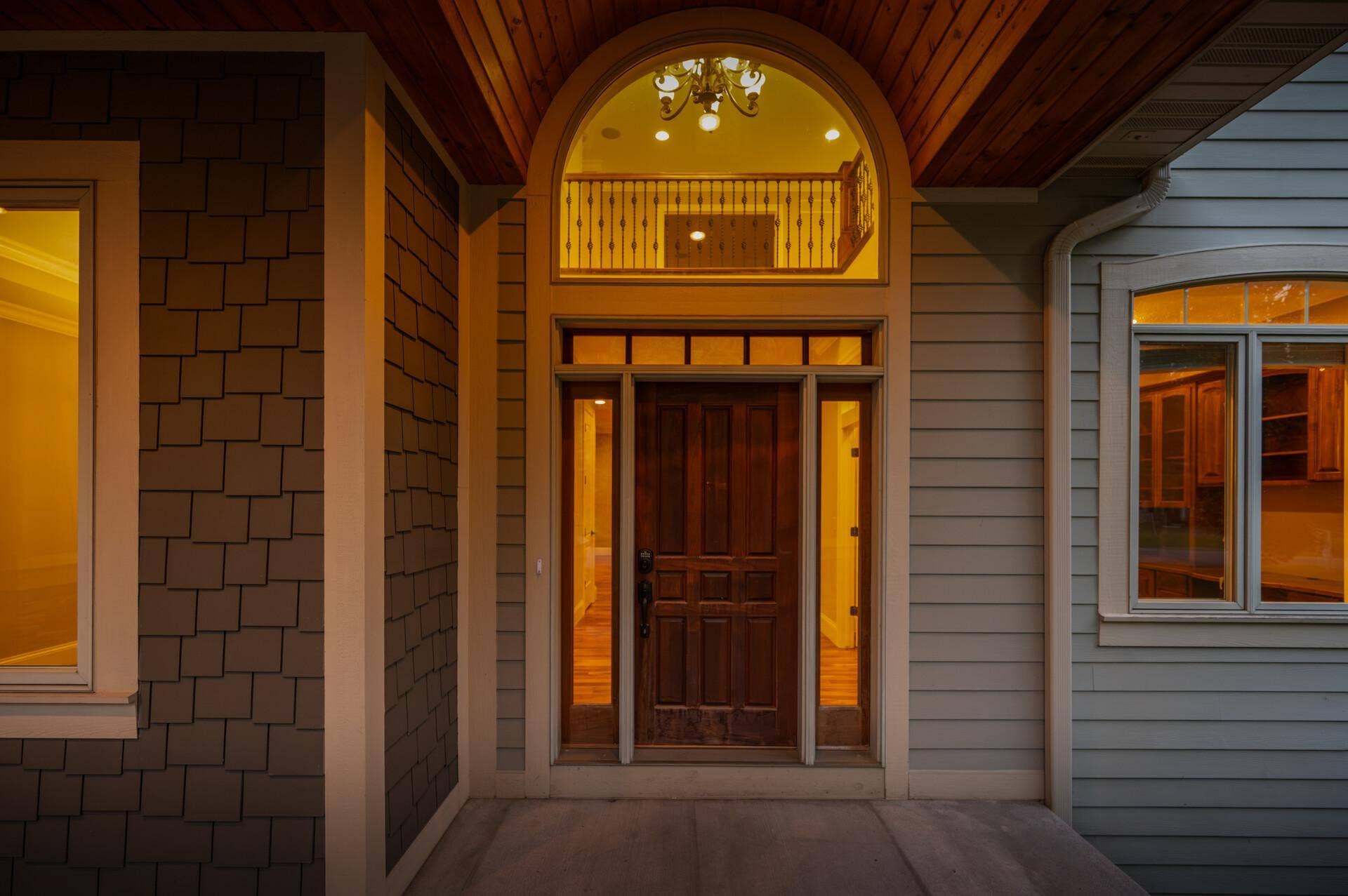 An impressive front entry is framed by dual sidelights and a transom window, while a dramatic half-moon window above draws in even more natural light and adds to the homes grand sense of arrival.