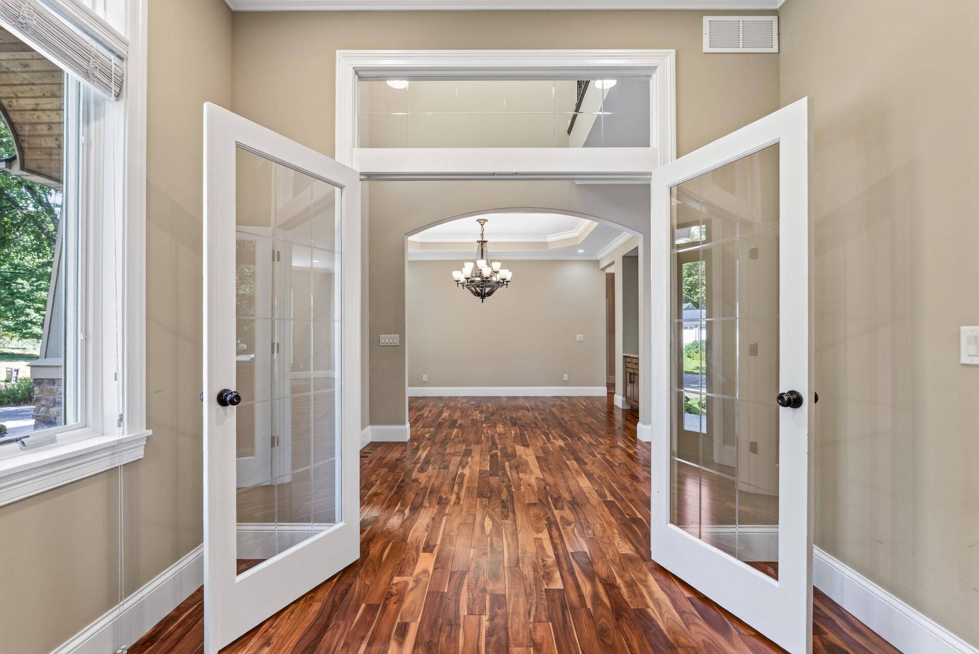 Double glass doors topped by a transom window create an elegant entrance to the main-level office while allowing natural light to flow beautifully through the space.
