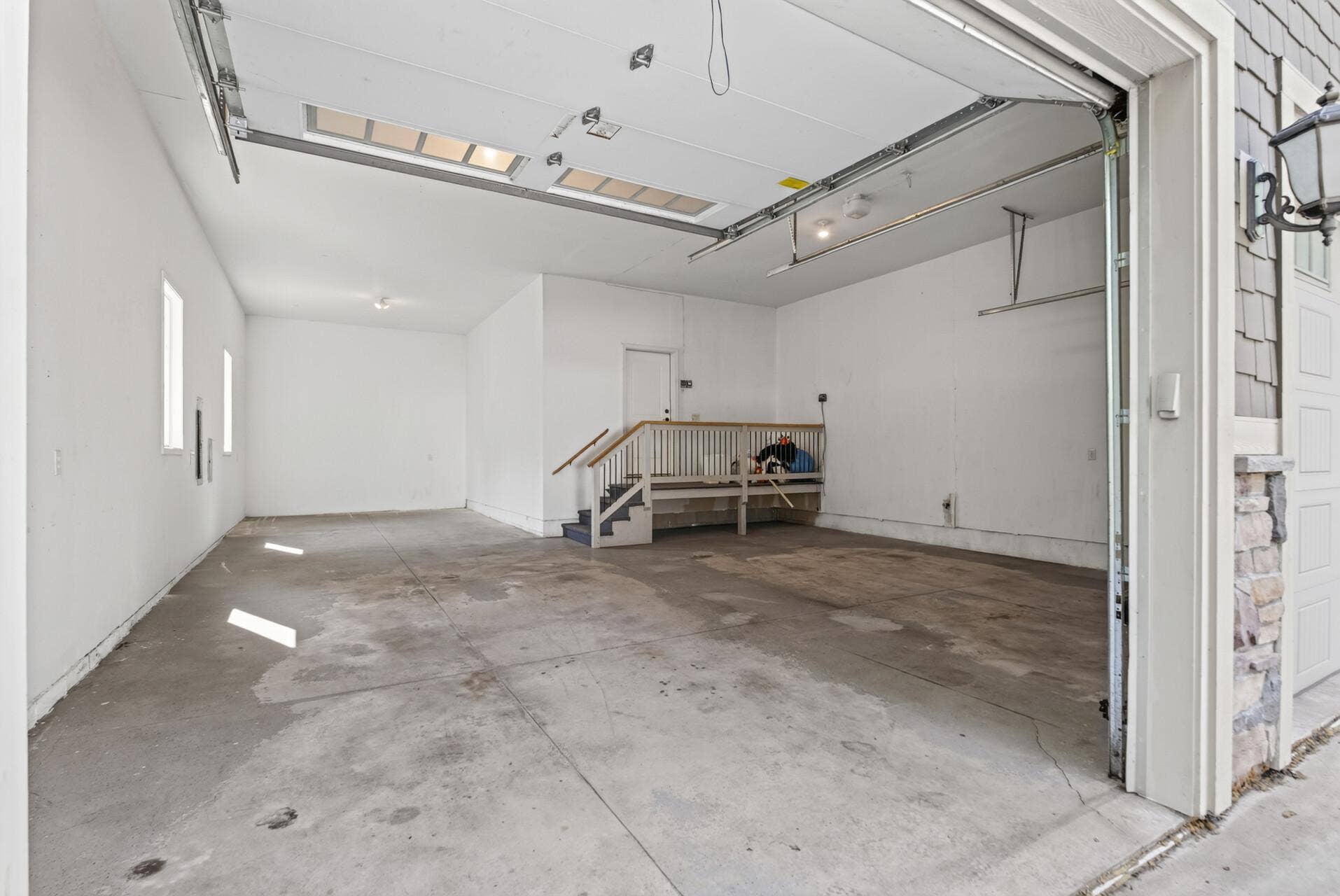 The oversized 3-car garage is impressive in both scale and versatility, with soaring ceilings well beyond standard garage height.