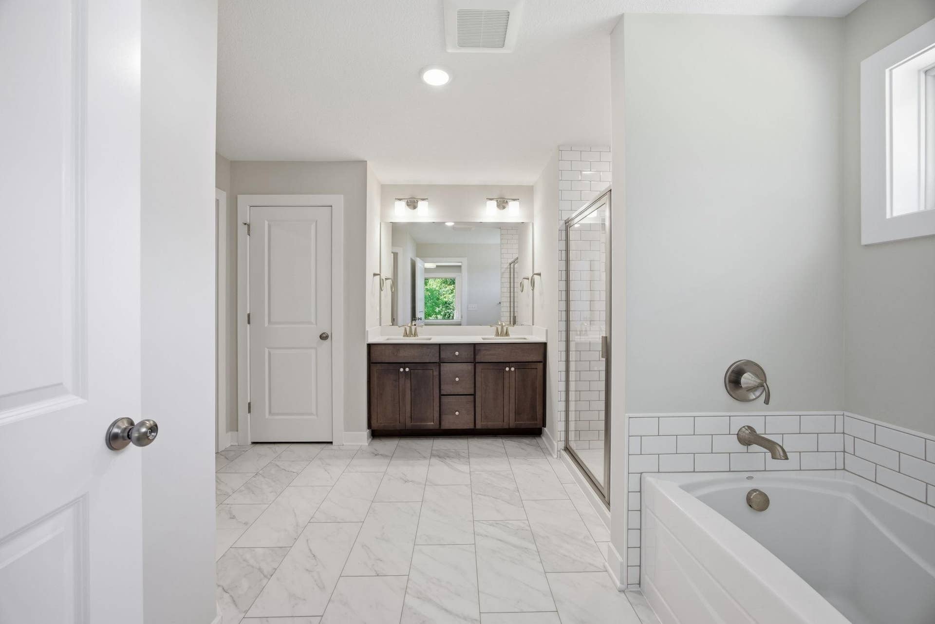 2399 Laurie Court W, Roseville, MN 55113 Primary luxurious private bath with a soaking tub, walk-in shower, dual vanities, and a large walk-in dressing room.