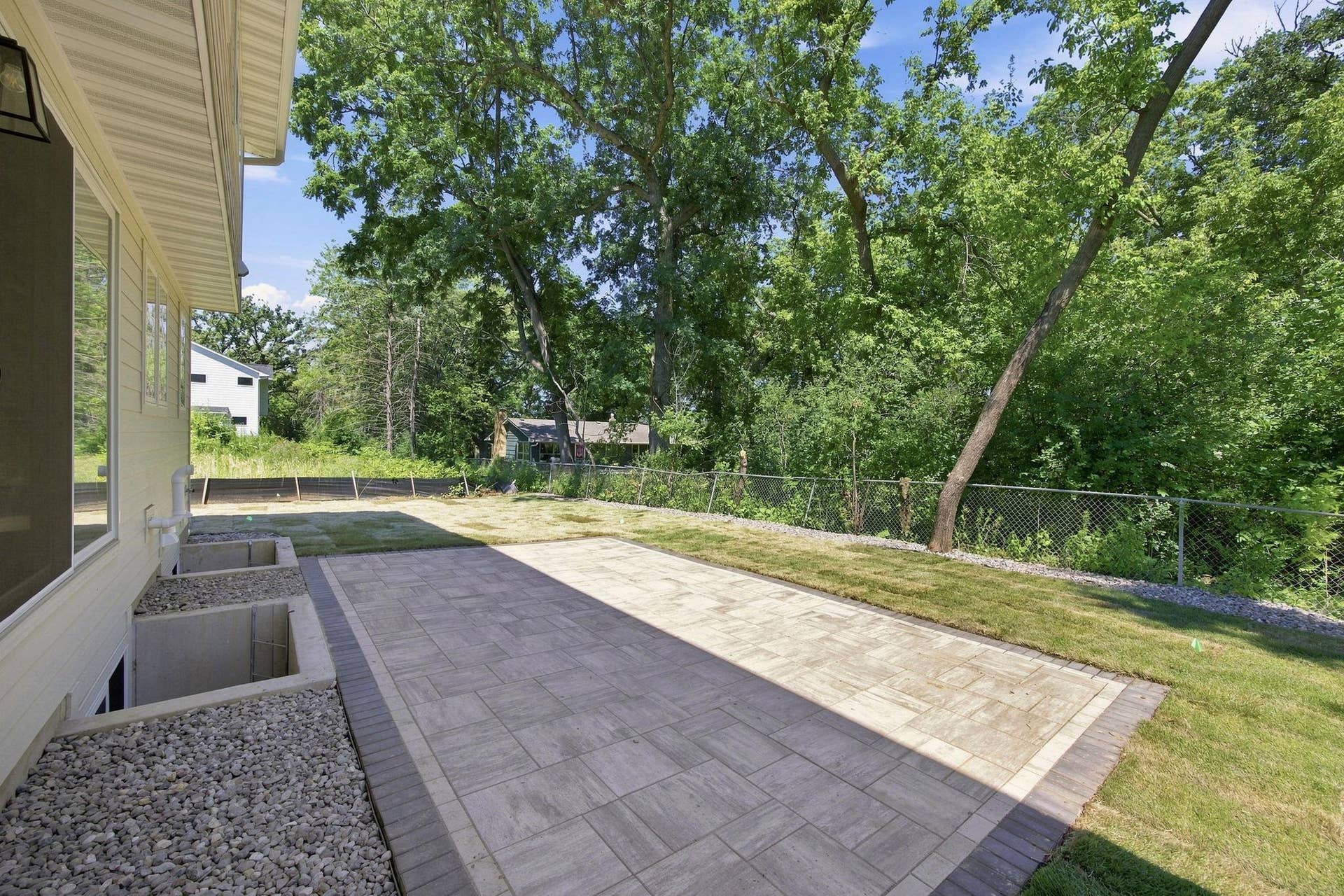 2399 Laurie Court W, Roseville, MN 55113 Close-up view of the new stone patio completed in July 2026. The exterior stairs connecting the house to the patio will be installed by the builder prior to closing.