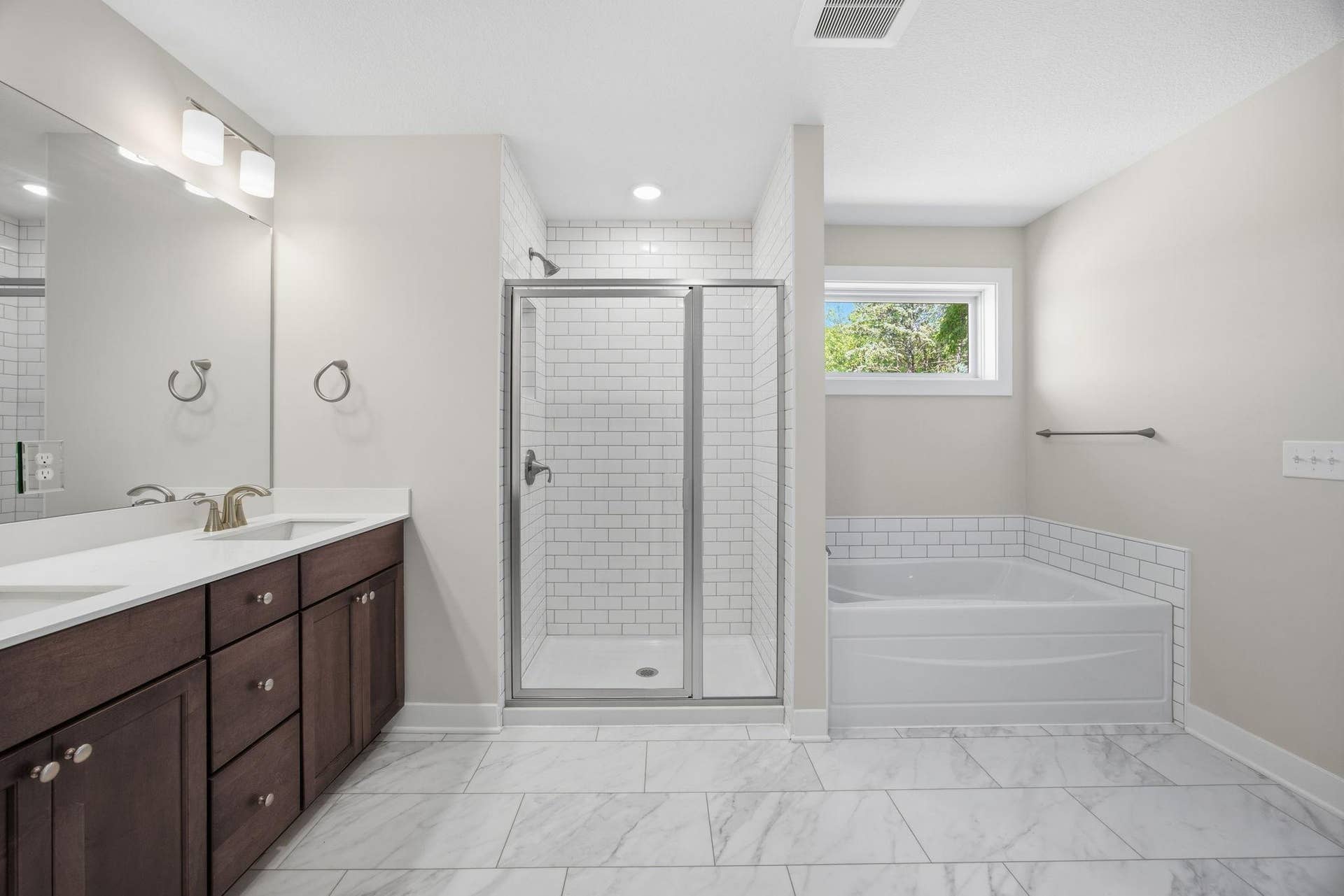 2399 Laurie Court W, Roseville, MN 55113 Another view of the primary luxurious private bath with a soaking tub, walk-in shower, dual vanities, and a large walk-in dressing room.
