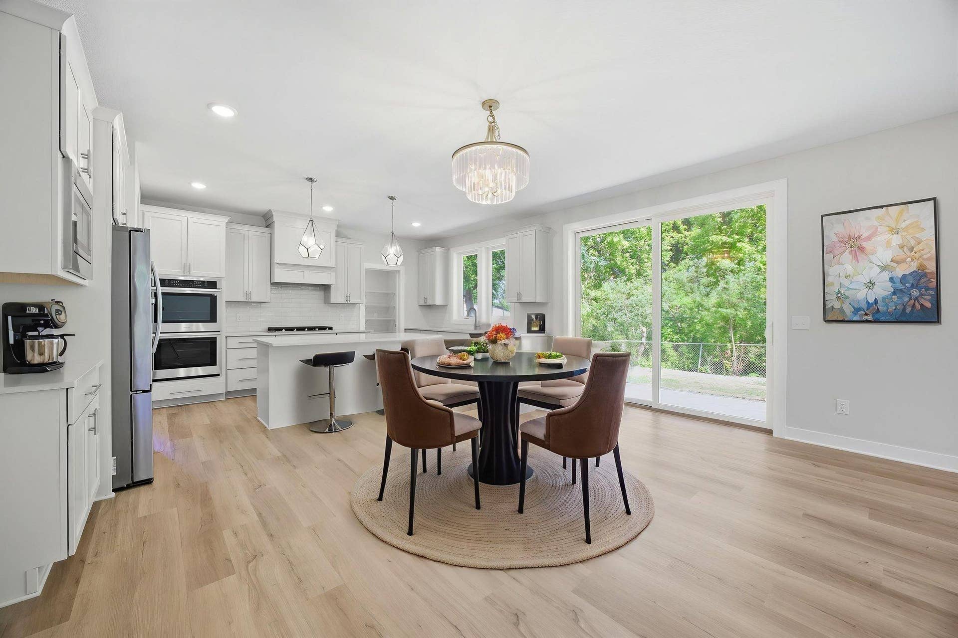 2399 Laurie Court W, Roseville, MN 55113 The kitchen/informal dining room area, features quartz countertops, a center island with a breakfast bar, a porcelain tile backsplash, SS appliances, and an extraordinary 15' x 6' walk-in pantry, offering exceptional storage and functionality.