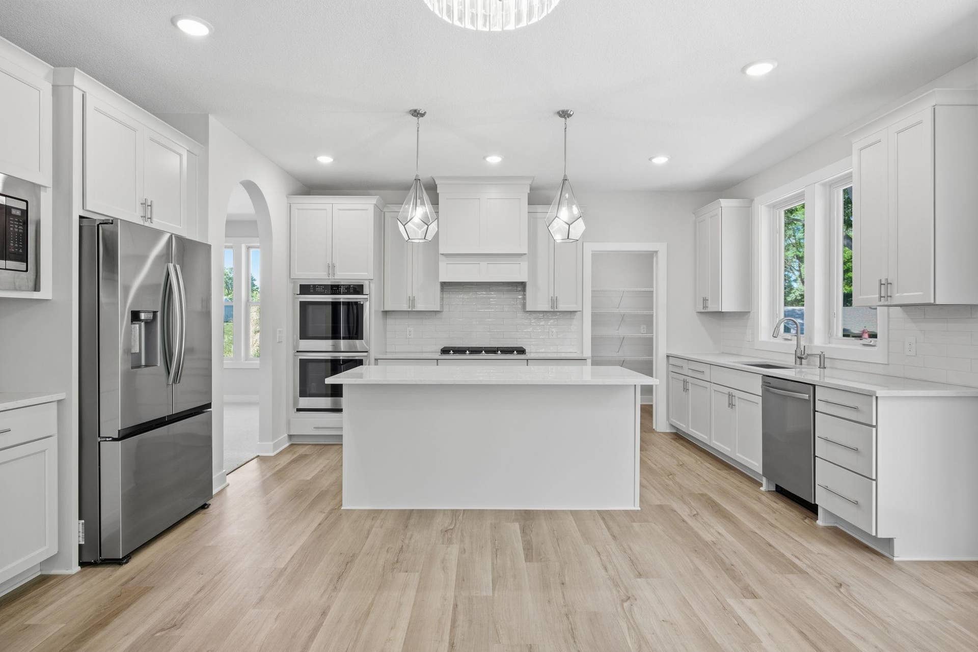 2399 Laurie Court W, Roseville, MN 55113 A closer look at the gourmet kitchen, featuring quartz countertops, a center island, stainless steel appliances, access to the impressive 15' x 6' walk-in pantry, and the formal dining room to the left.
